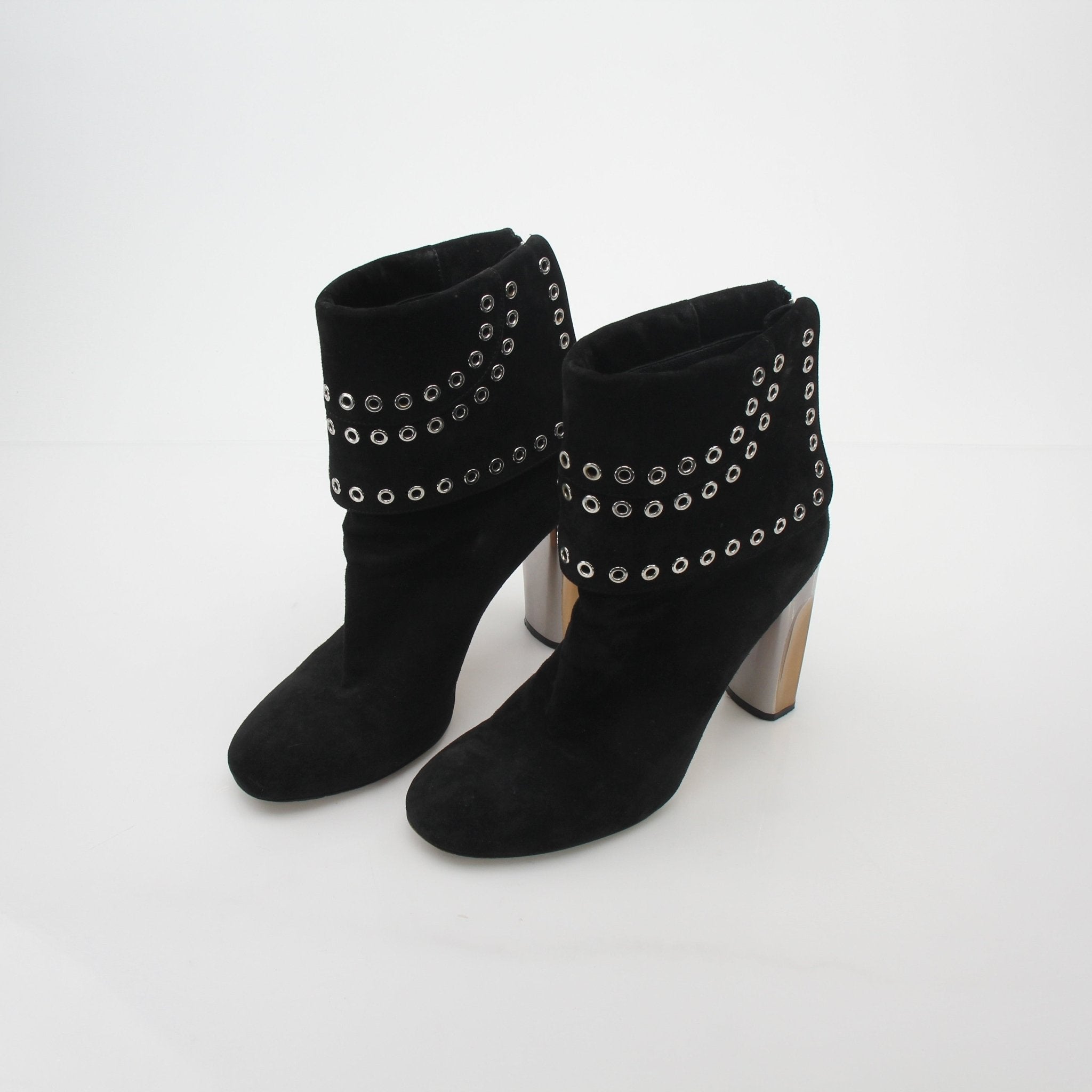 Black Alexander McQueen grommet fold-over ankle boots with chunky soles and silver hardware, styled with black leather.