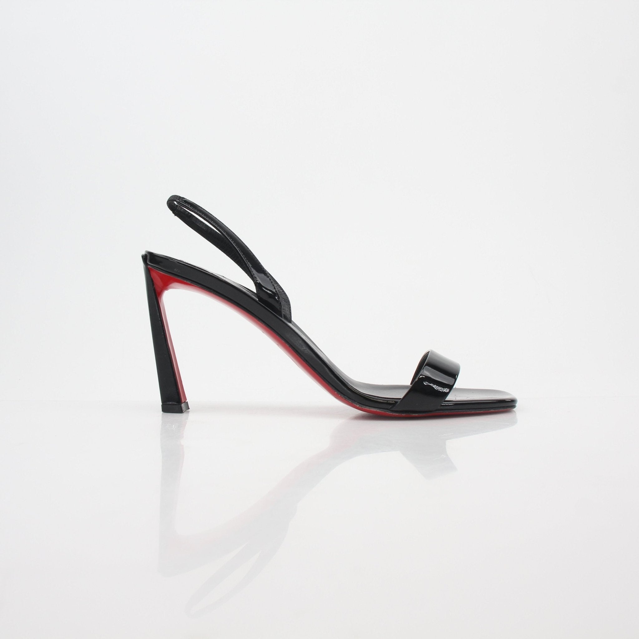 Black Christian Louboutin Condora Queen patent leather sandals with stiletto heels, showcased on a neutral background.