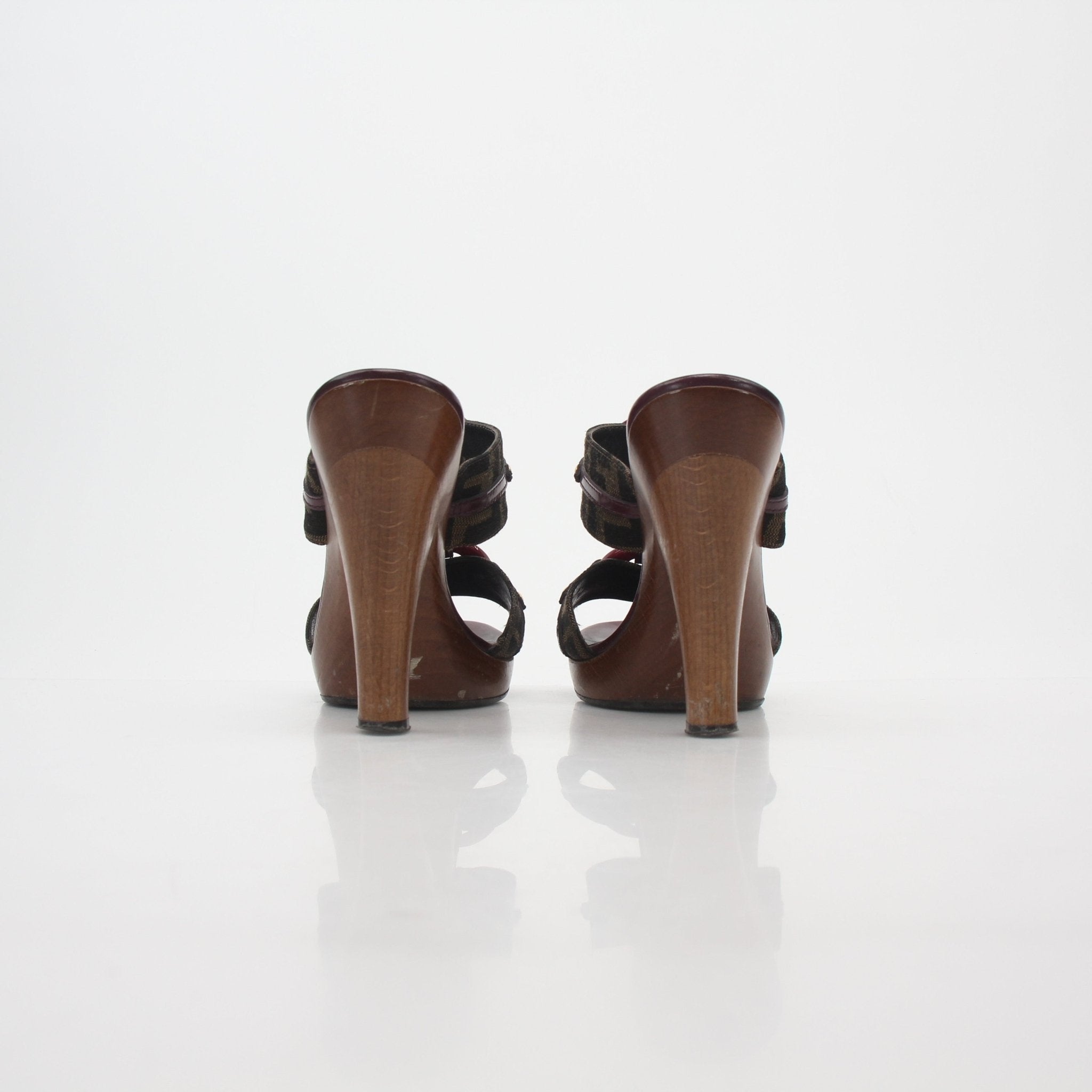 Fendi brown Zucca canvas platform sandals with heels, featuring signature pattern and ankle straps, on a neutral background.