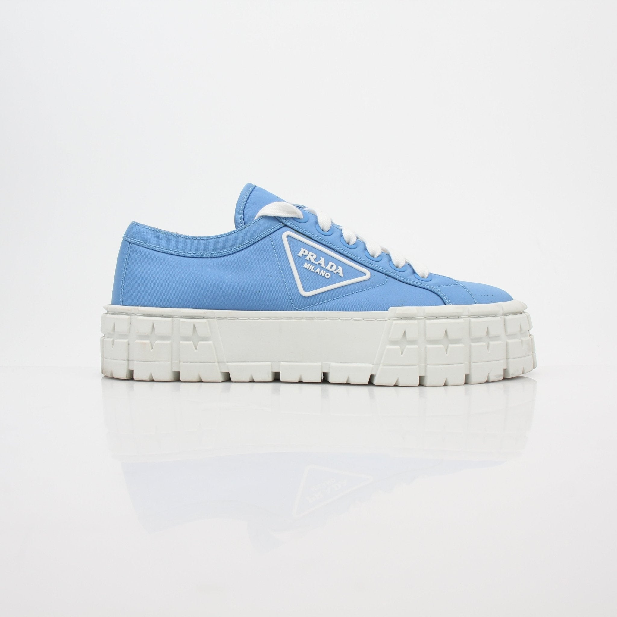 Light blue Prada double wheel low top sneakers for women, featuring stylish gold accents and a sleek shoe design.