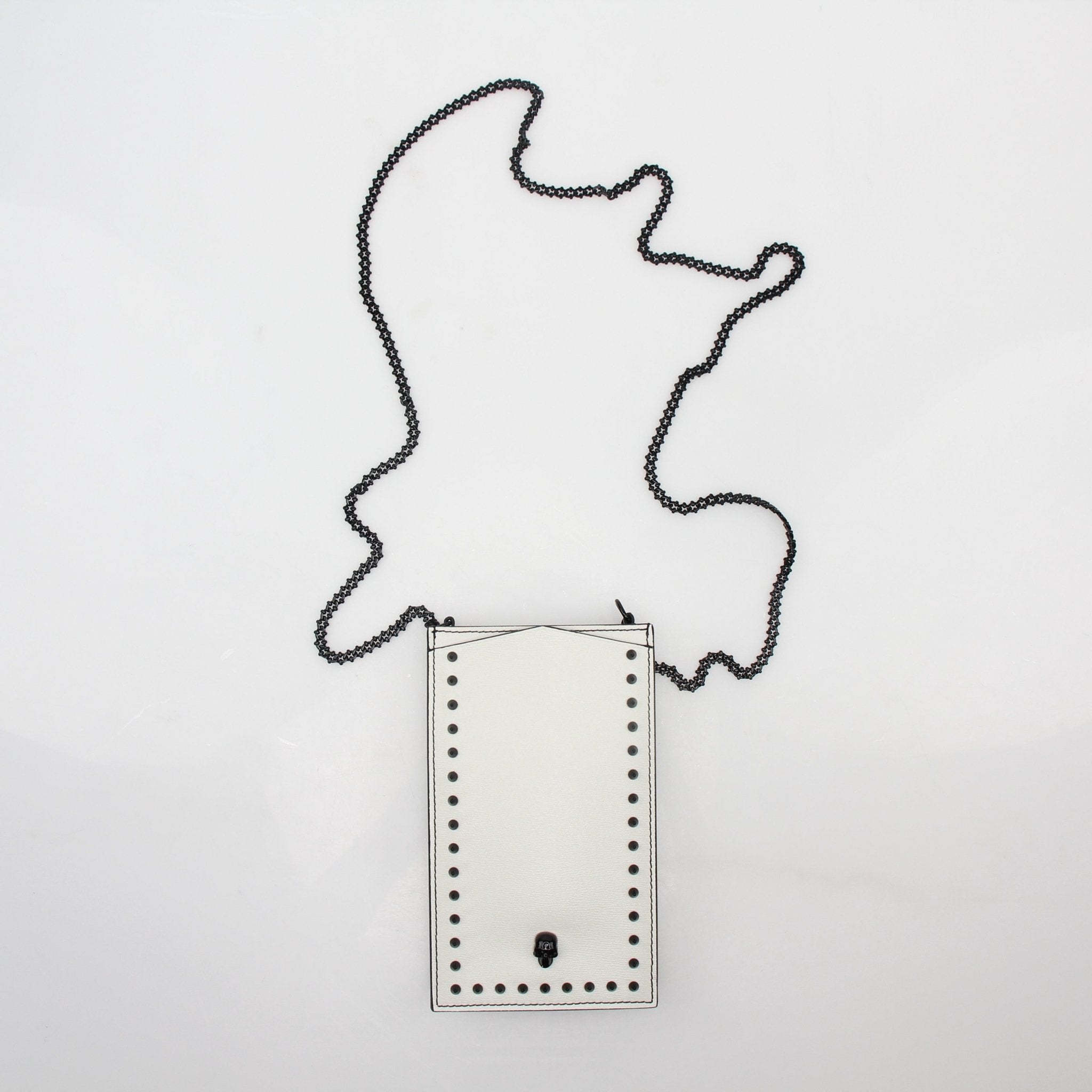 Alexander McQueen white skull stud phone case on chain, featuring a sleek handbag design with silver hardware and chain strap.