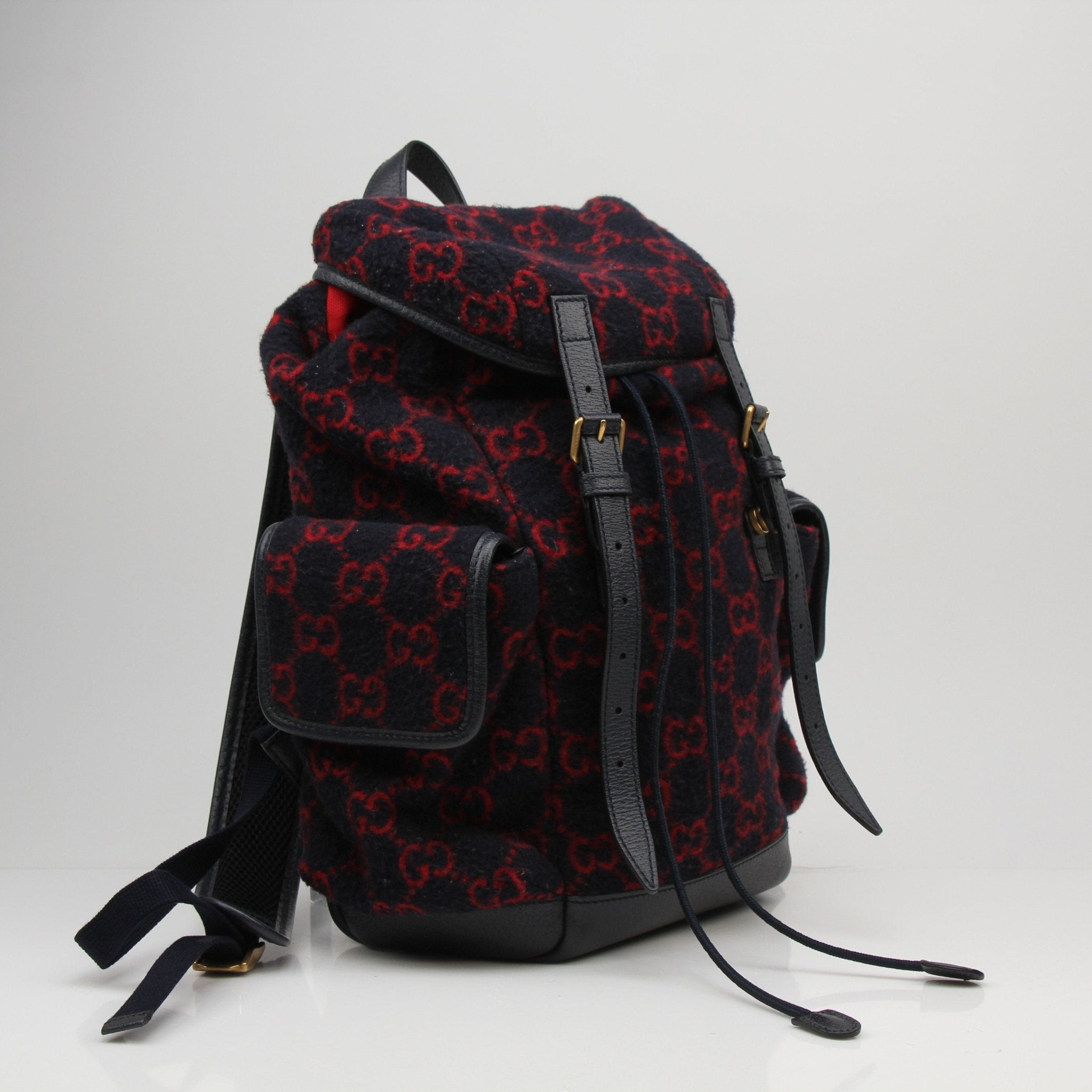 Gucci GG Monogram backpack handbag with gold accents and adjustable straps, featuring the iconic monogram pattern.