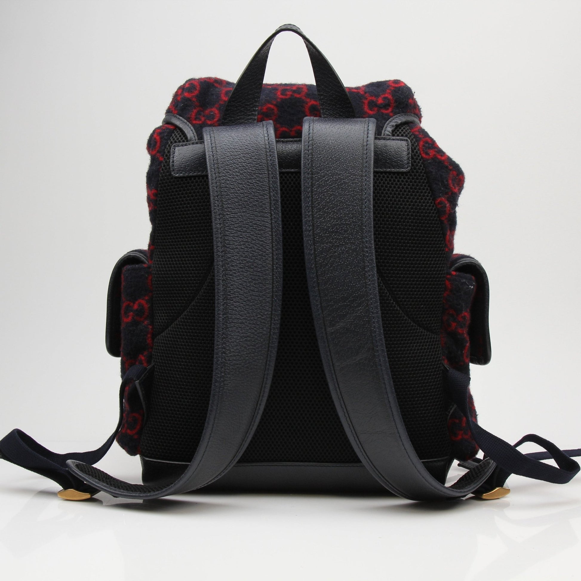 Gucci GG Monogram Backpack handbag with gold accents, featuring monogram pattern and adjustable straps.