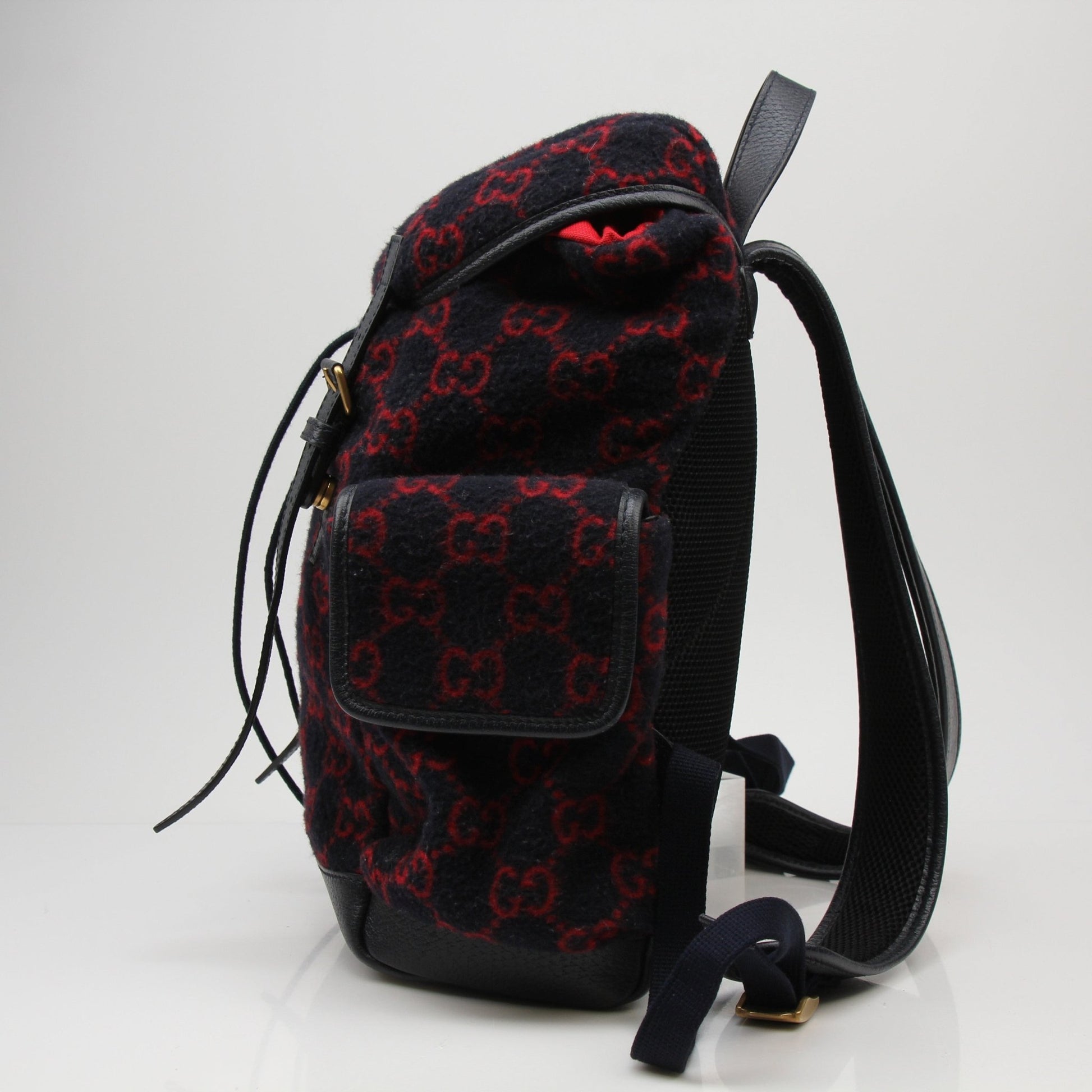 Gucci GG Monogram backpack handbag with adjustable straps and gold hardware, featuring iconic monogram pattern.