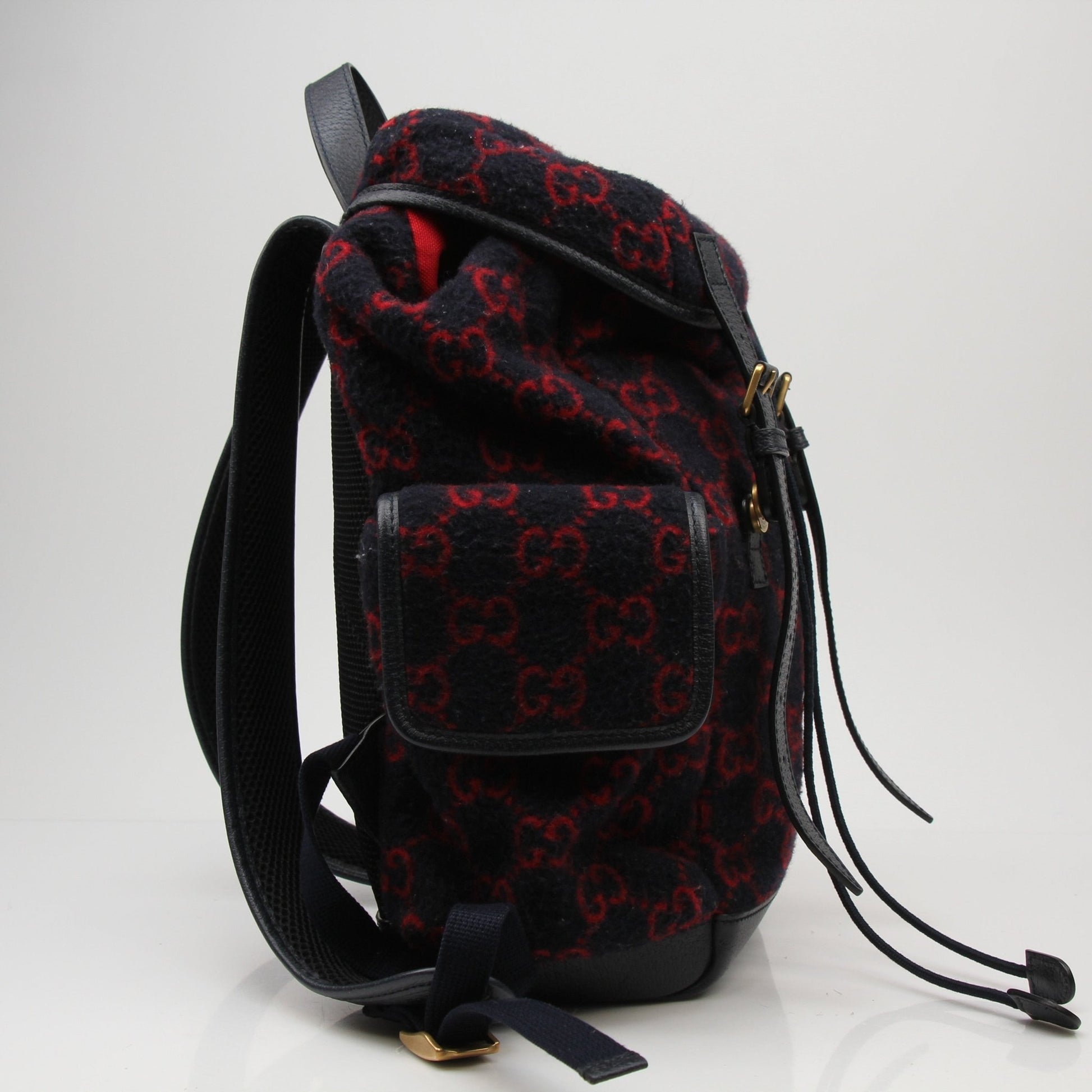 Gucci GG Monogram backpack handbag with leather straps and gold hardware, stylish and functional accessory.