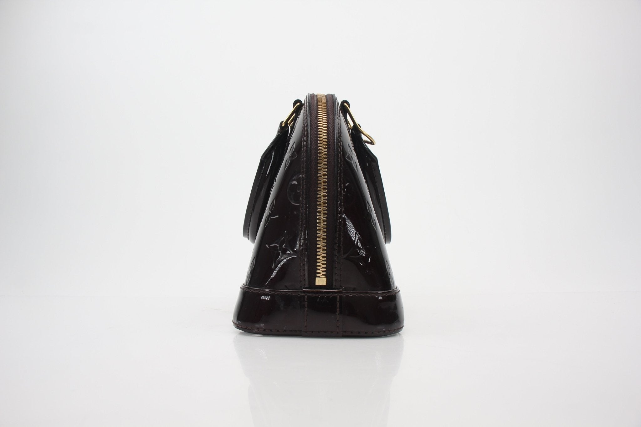 Louis Vuitton Monogram Vernis Alma BB handbag with gold-tone hardware and structured shape, featuring signature monogram pattern.