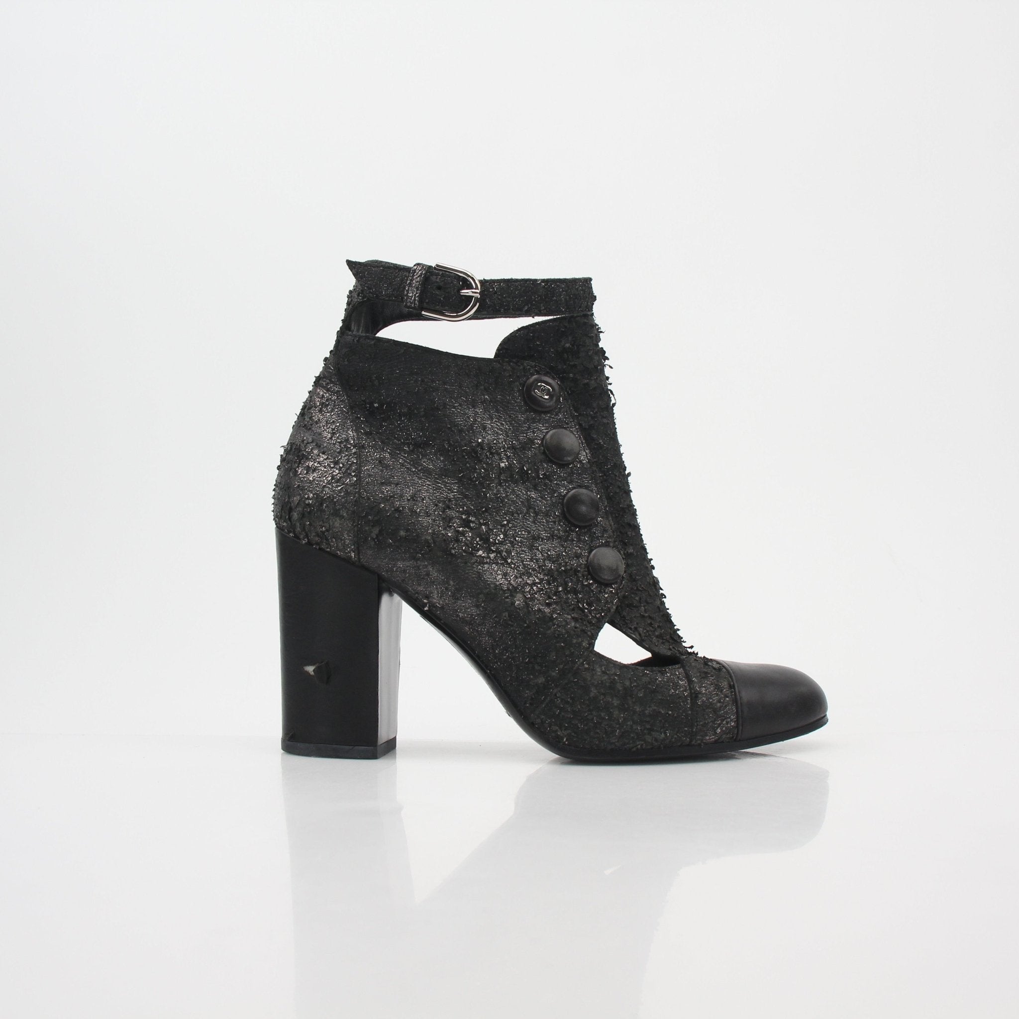 Gold & Beyond Chanel black distressed cutout ankle boots with chunky heels and stylish design, shown on a white background.