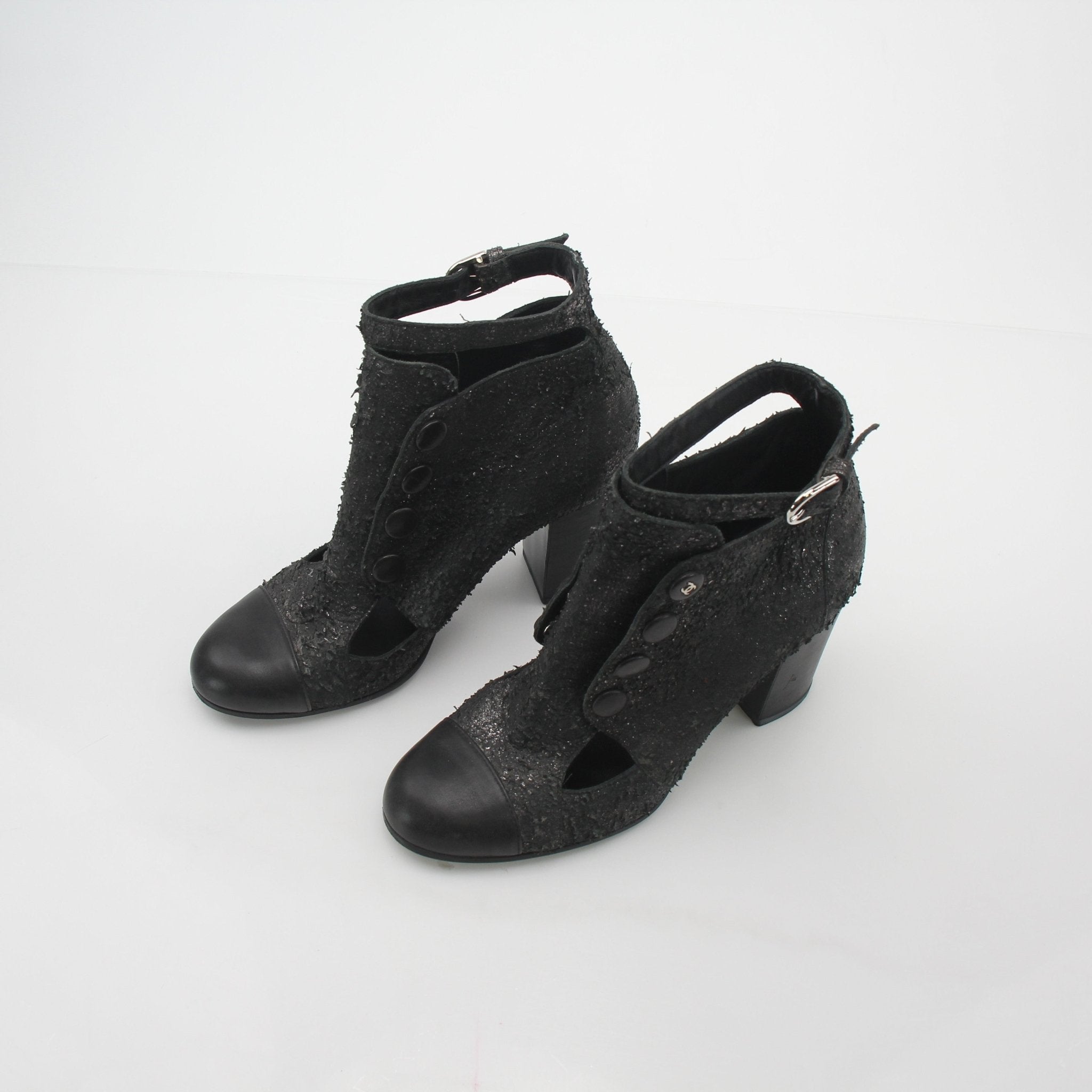 Gold & Beyond Chanel black distressed cutout ankle boots, stylish shoes with edgy design and ankle-length silhouette.