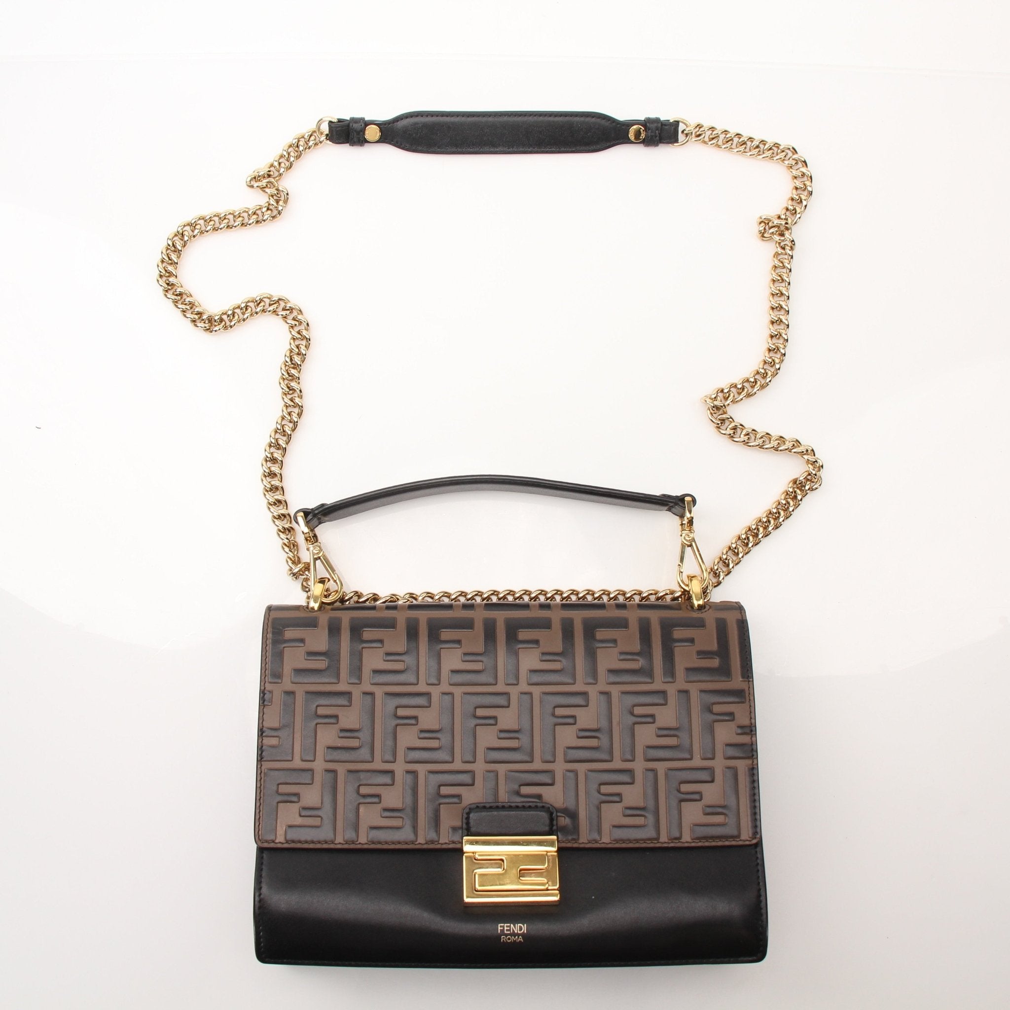 Fendi FF Kan shoulder handbag with gold hardware and signature monogram pattern, carried by hand with a chain strap.
