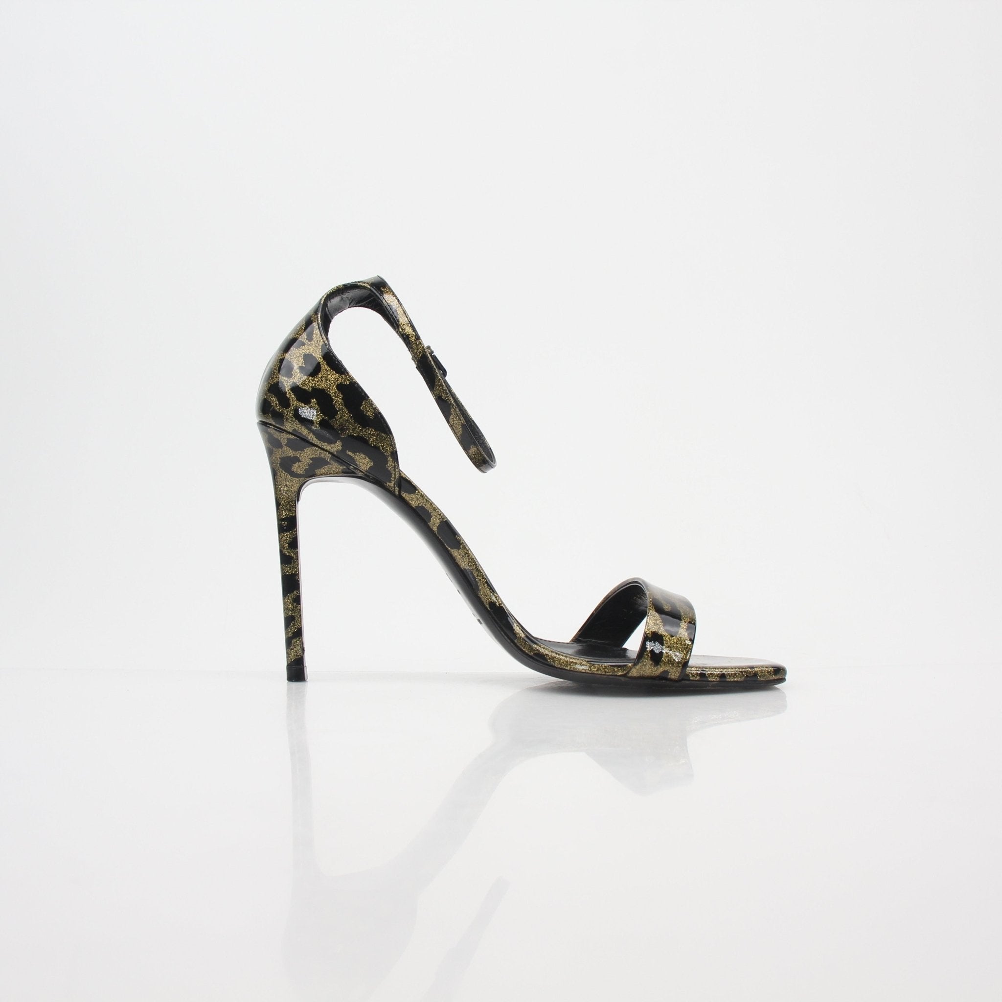 Gold & Beyond Saint Laurent black and gold amber ankle-strap heels with stiletto heels and sleek design.