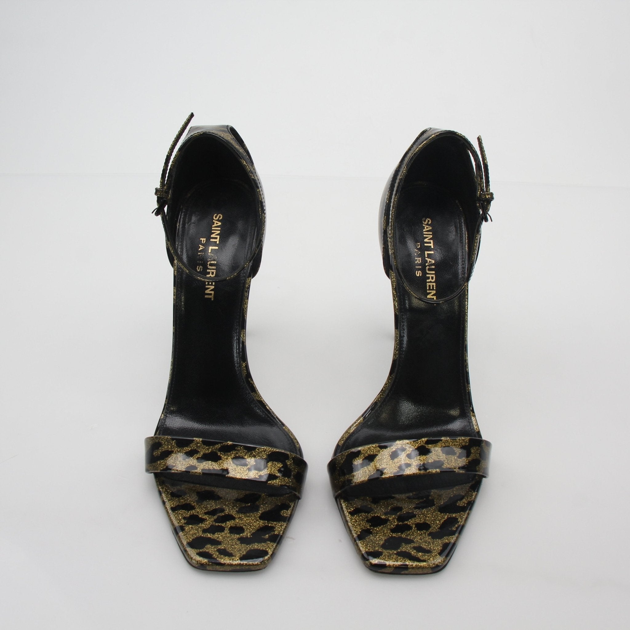 Saint Laurent black and gold amber ankle-strap sandals, stylish heels with gold accents and a sleek design.