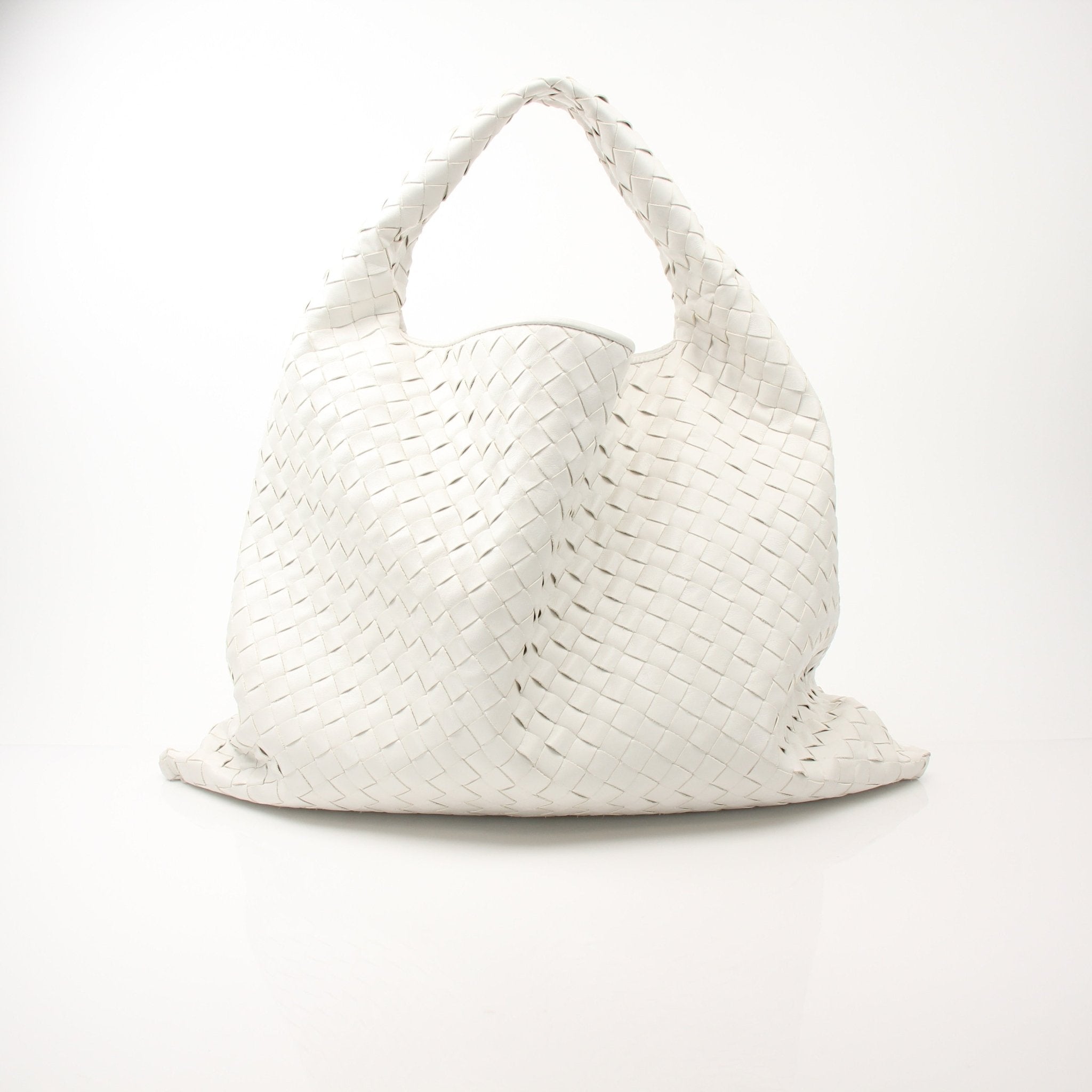 Large white Bottega Veneta Intrecciato leather hobo handbag with slouchy design and top handle, showing textured woven pattern.