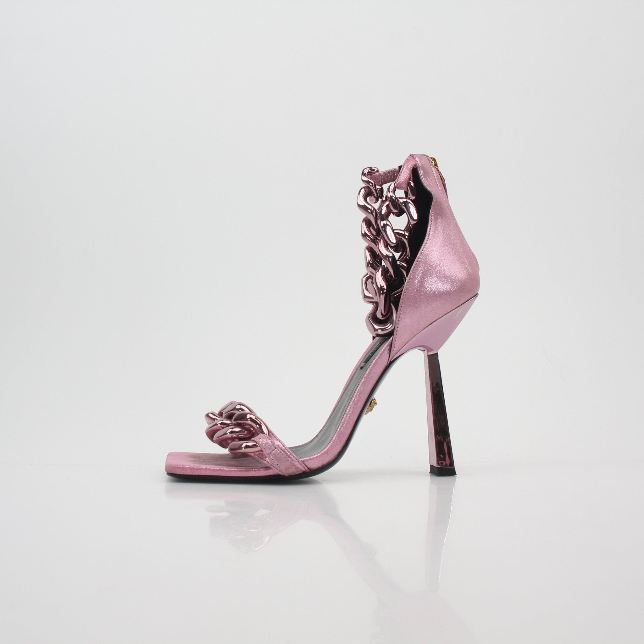 Pink Medusa chain sandals by Versace featuring high heels with gold accents and Medusa embellishments on straps.