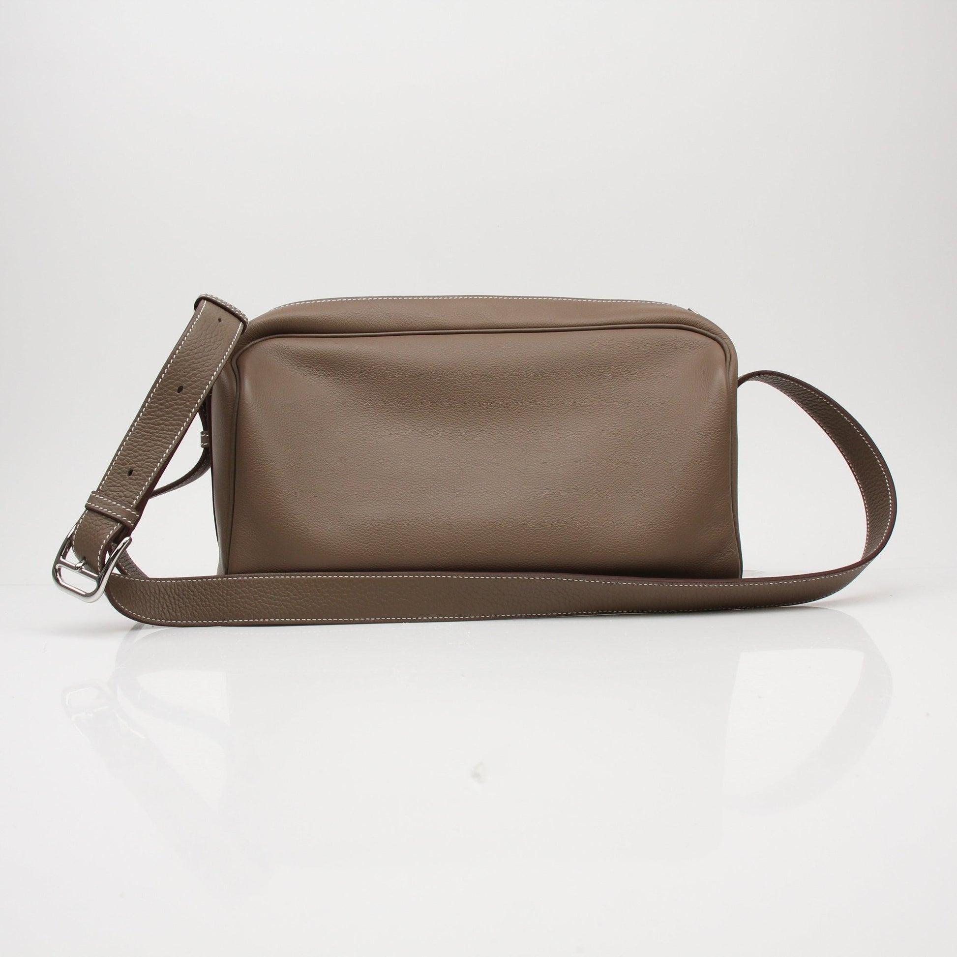 Hermès Petite Courrier handbag in tan leather with gold hardware, displayed on a neutral background.