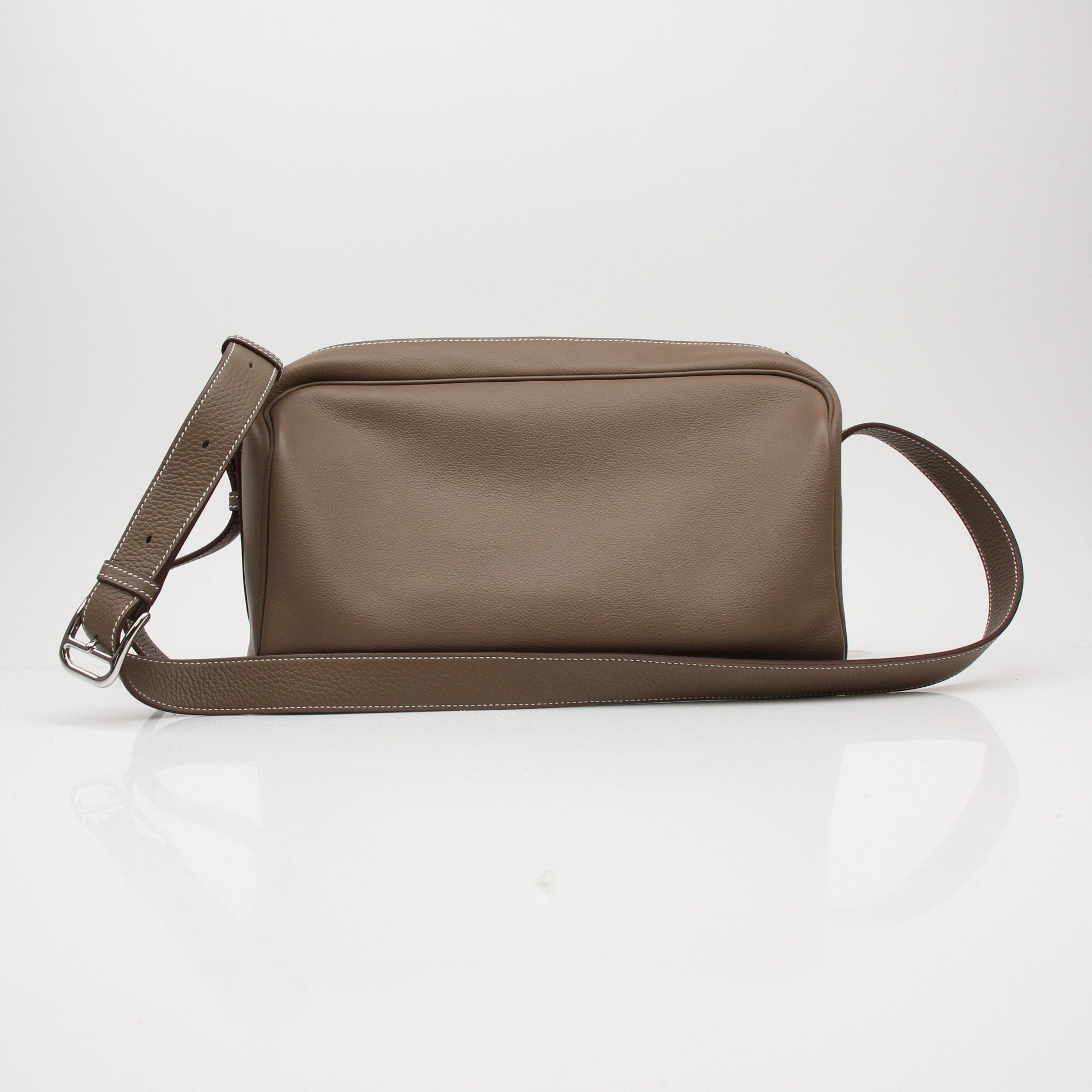 Hermès Petite Courrier handbag in tan leather with gold hardware, displayed on a neutral background.