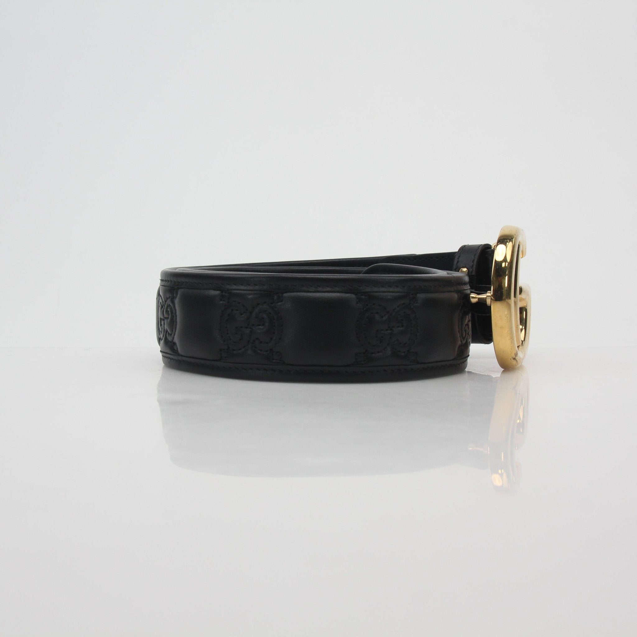 Black Gucci GG Marmont leather belt with gold hardware, showcasing the signature double G logo and sleek design.
