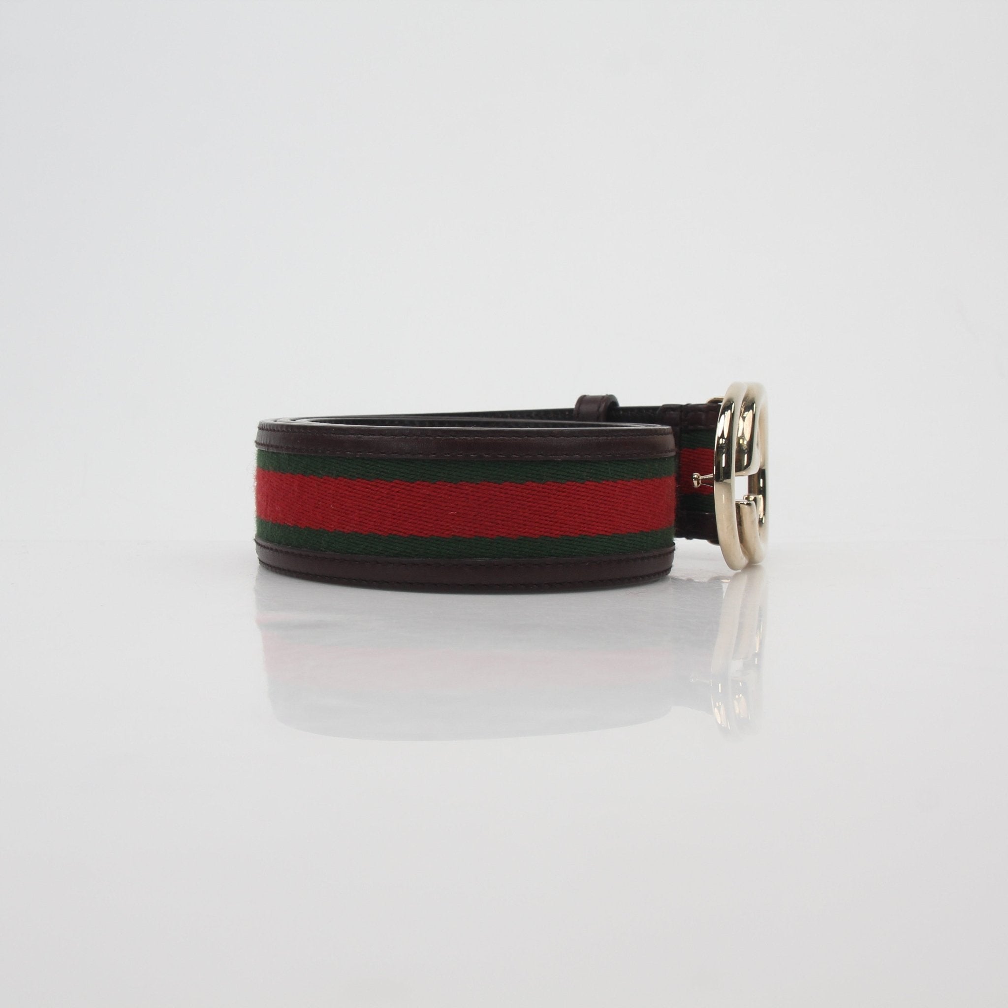 Gucci green and red interlocking G web belt, designer accessories with signature pattern and adjustable buckle, on a neutral background.