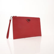 Red Prada saffiano leather wristlet pouch with gold hardware, compact handbag with a sleek design and wrist strap.