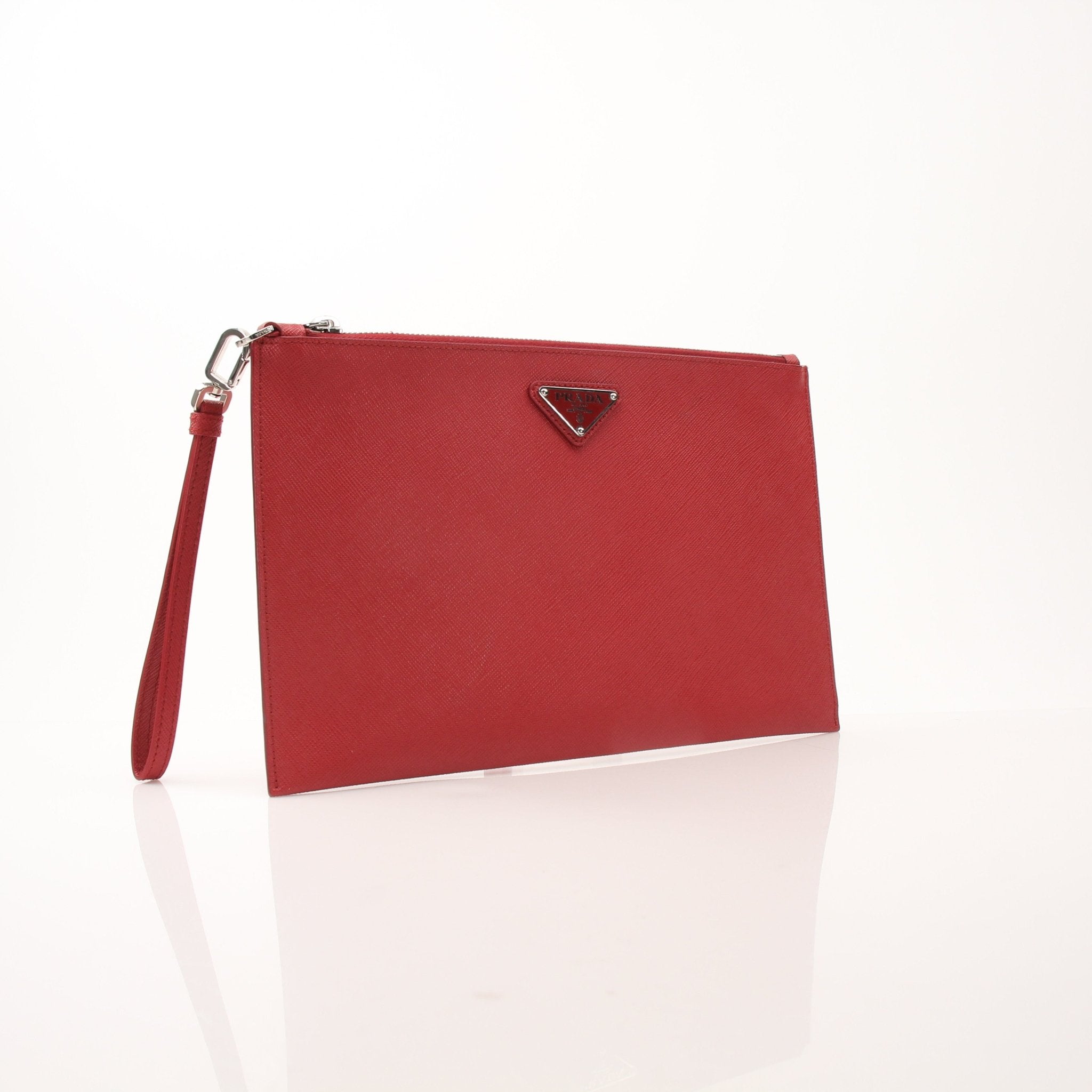 Red Prada saffiano leather wristlet pouch with gold hardware, compact handbag with a sleek design and wrist strap.