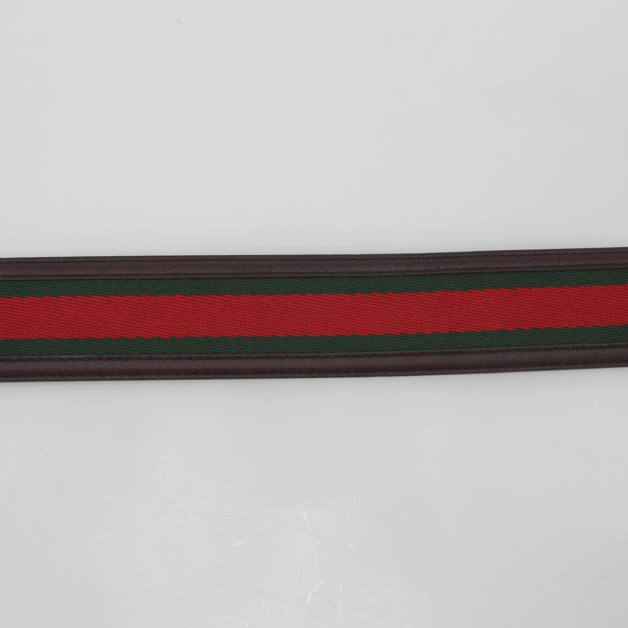 Green and red Gucci Interlocking G Web Belt with gold buckle, stylish accessories featuring iconic brand design.