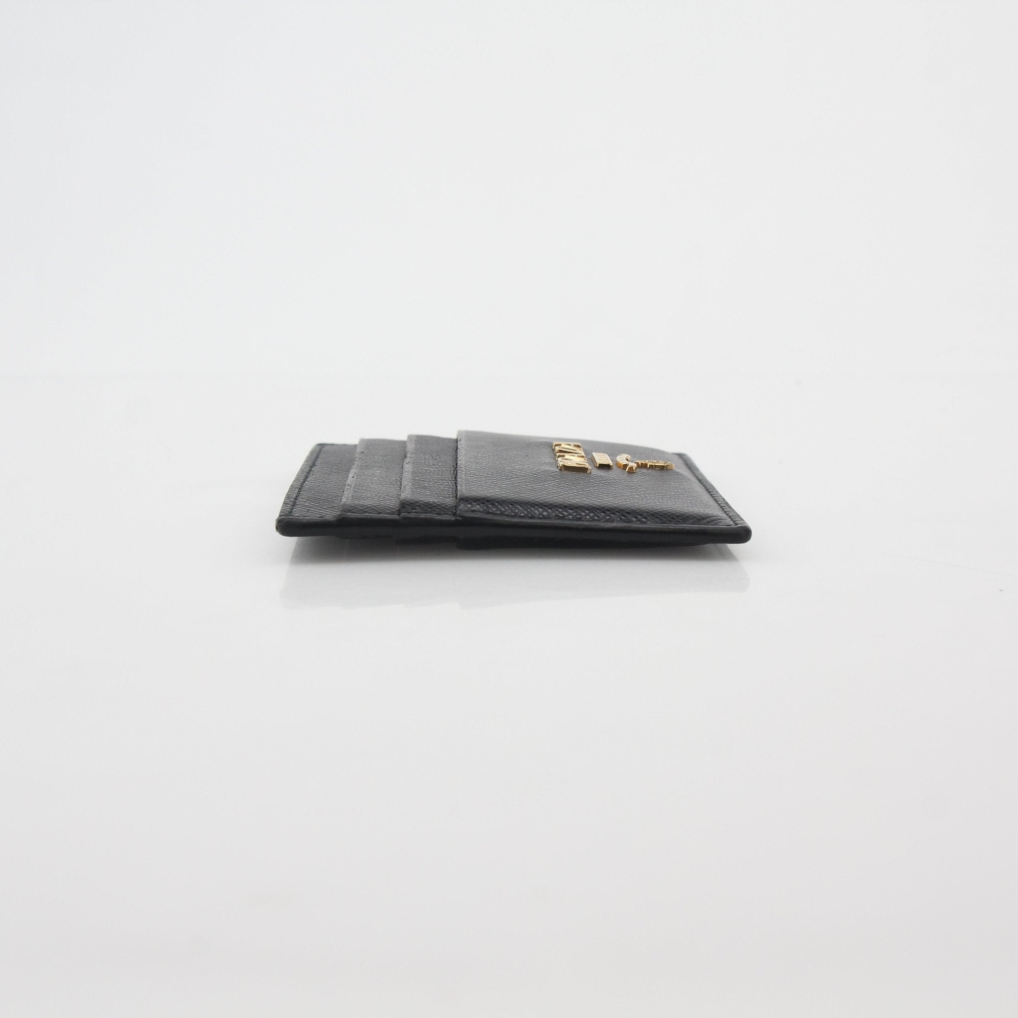 Prada black saffiano leather card holder with multiple card slots and gold-tone accents, compact and stylish for everyday use.