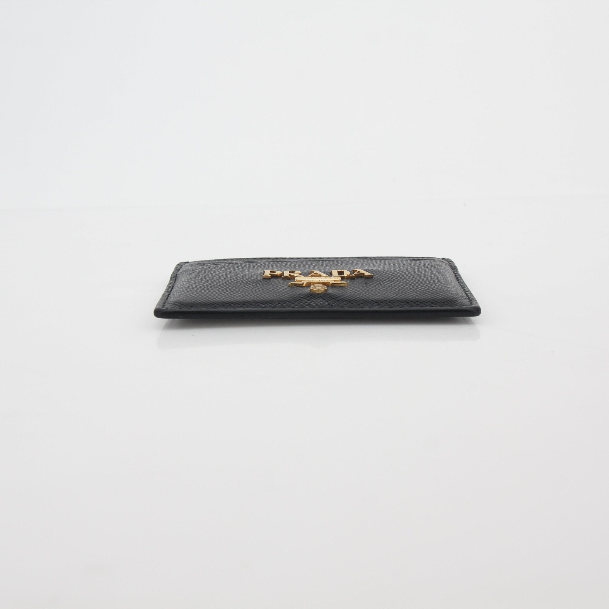 Prada black saffiano leather card holder with gold-tone logo and multiple card slots.