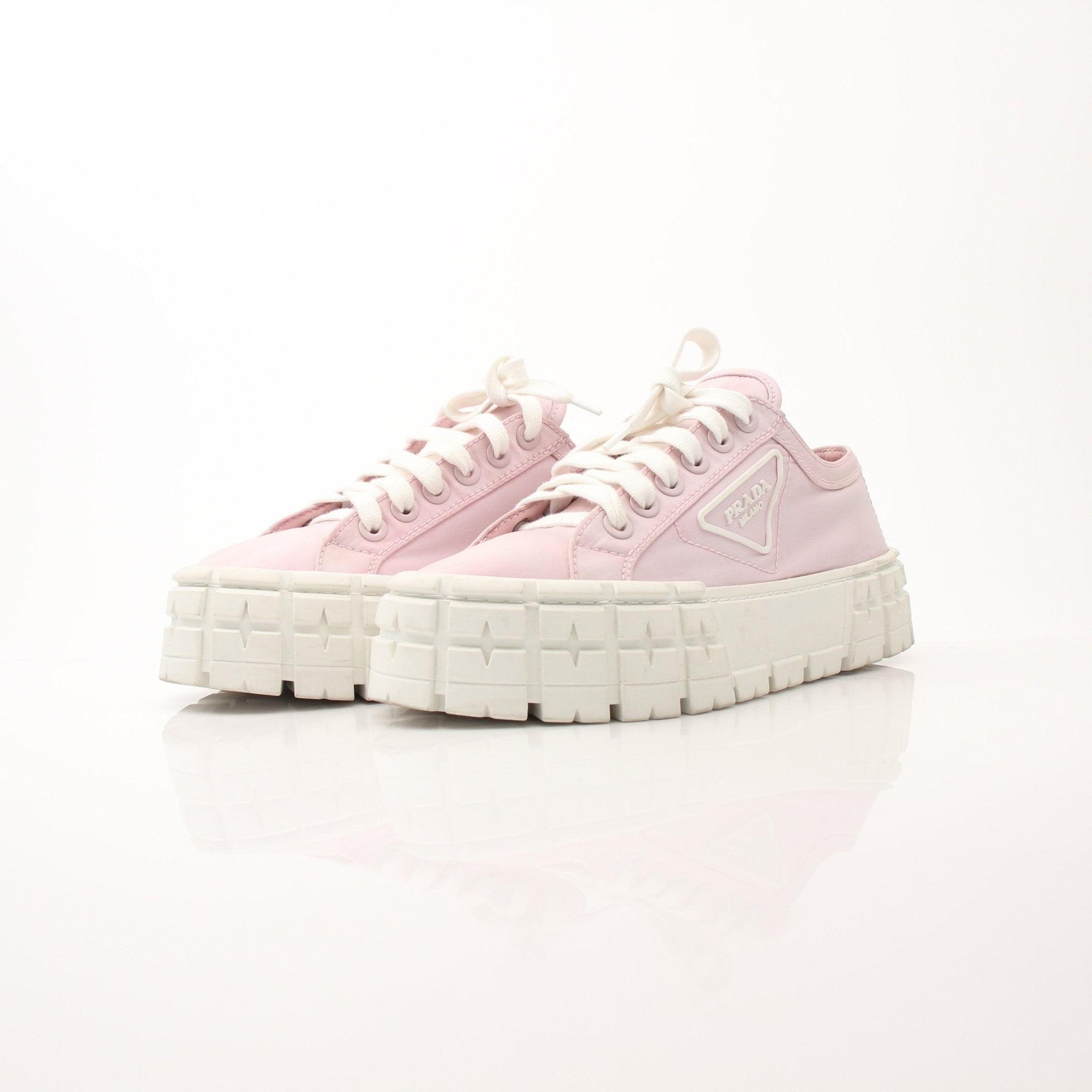 Prada pink nylon double wheel platform sneakers, stylish shoes with chunky soles and vibrant color, on a plain background.