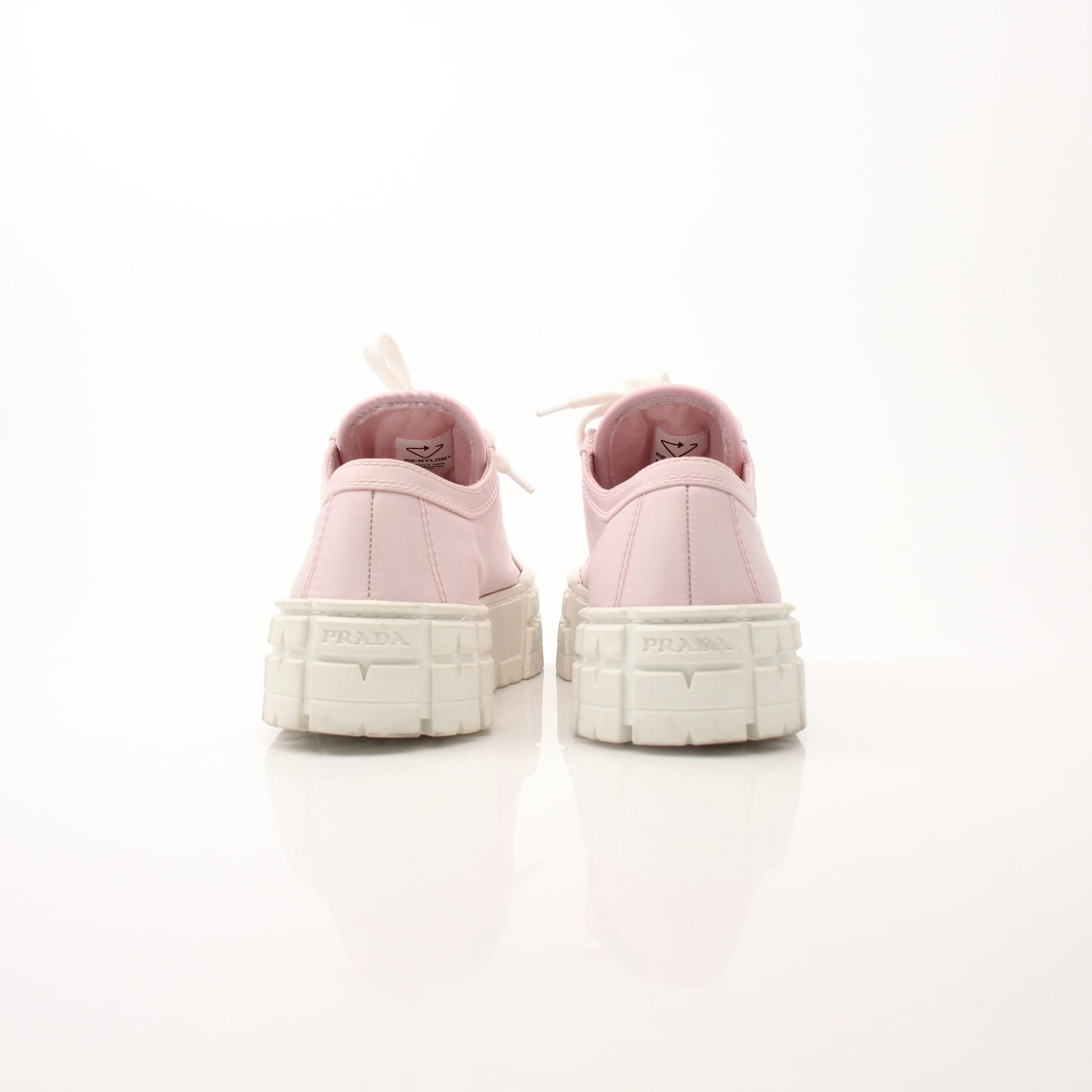 Pink Prada nylon double wheel platform sneakers with chunky soles and sporty design, shown on a clean background.