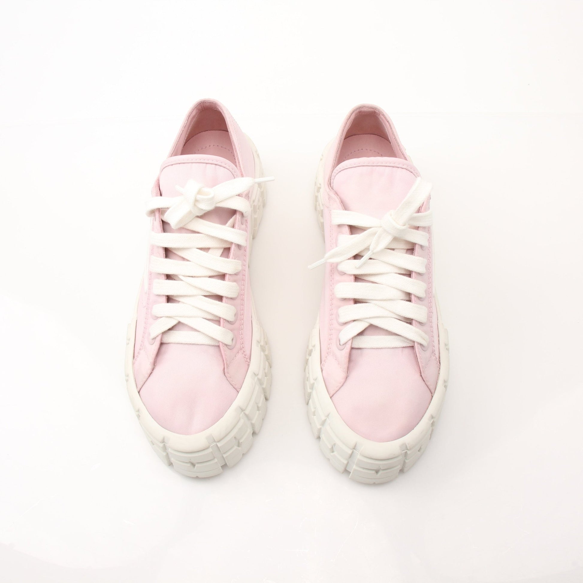 Prada pink nylon double wheel platform sneakers with white soles and laces, showcasing a trendy athletic shoe design.