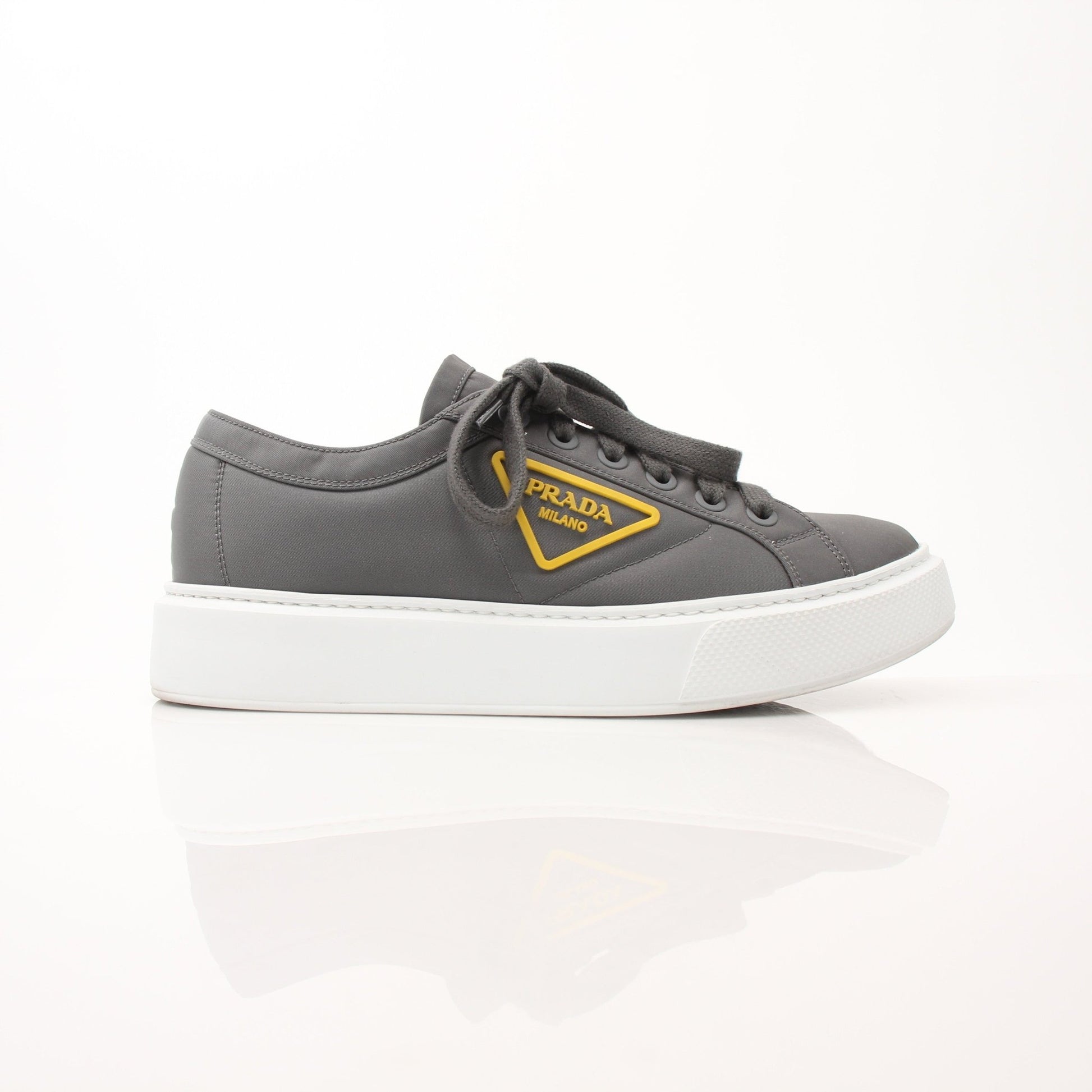 Prada gray Re-Nylon gabardine platform sneakers with white soles and sleek design, showcasing modern, eco-friendly footwear.