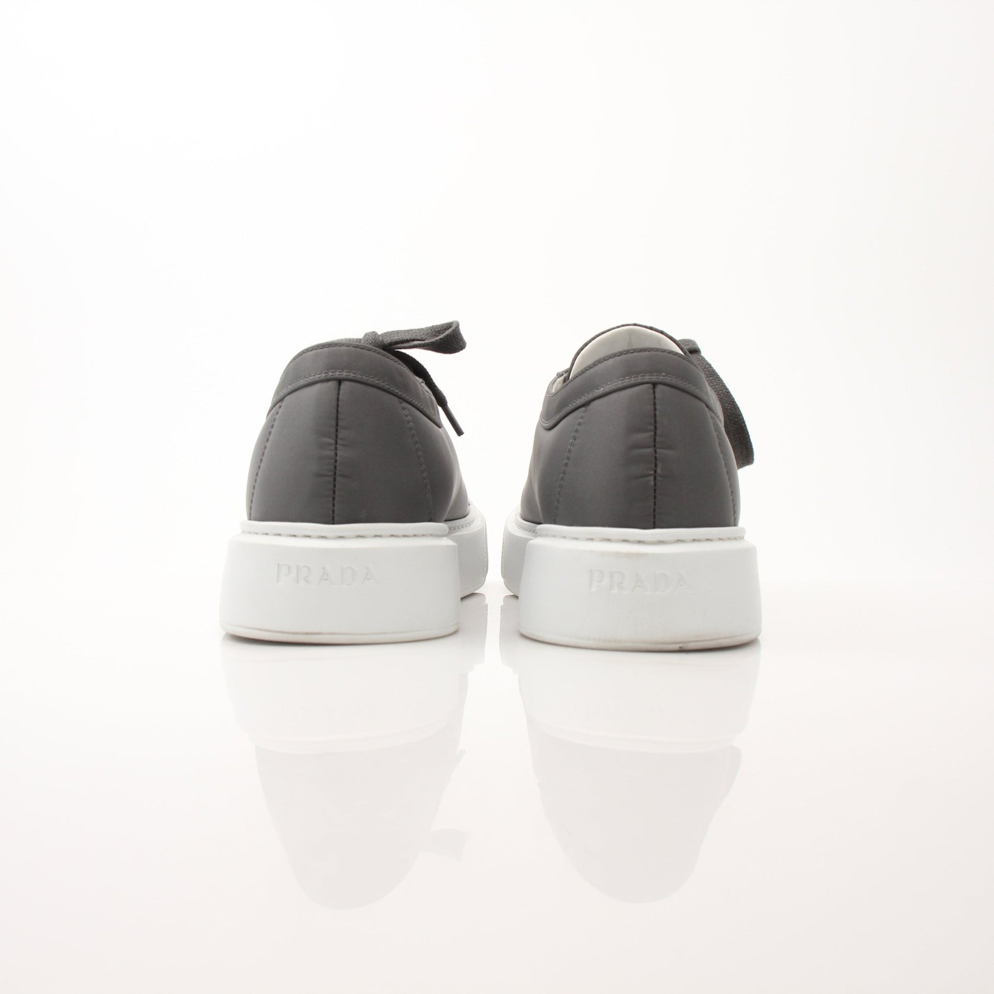 Prada gray Re-Nylon gabardine platform sneakers with white soles and lace-up design, displayed on a plain background.