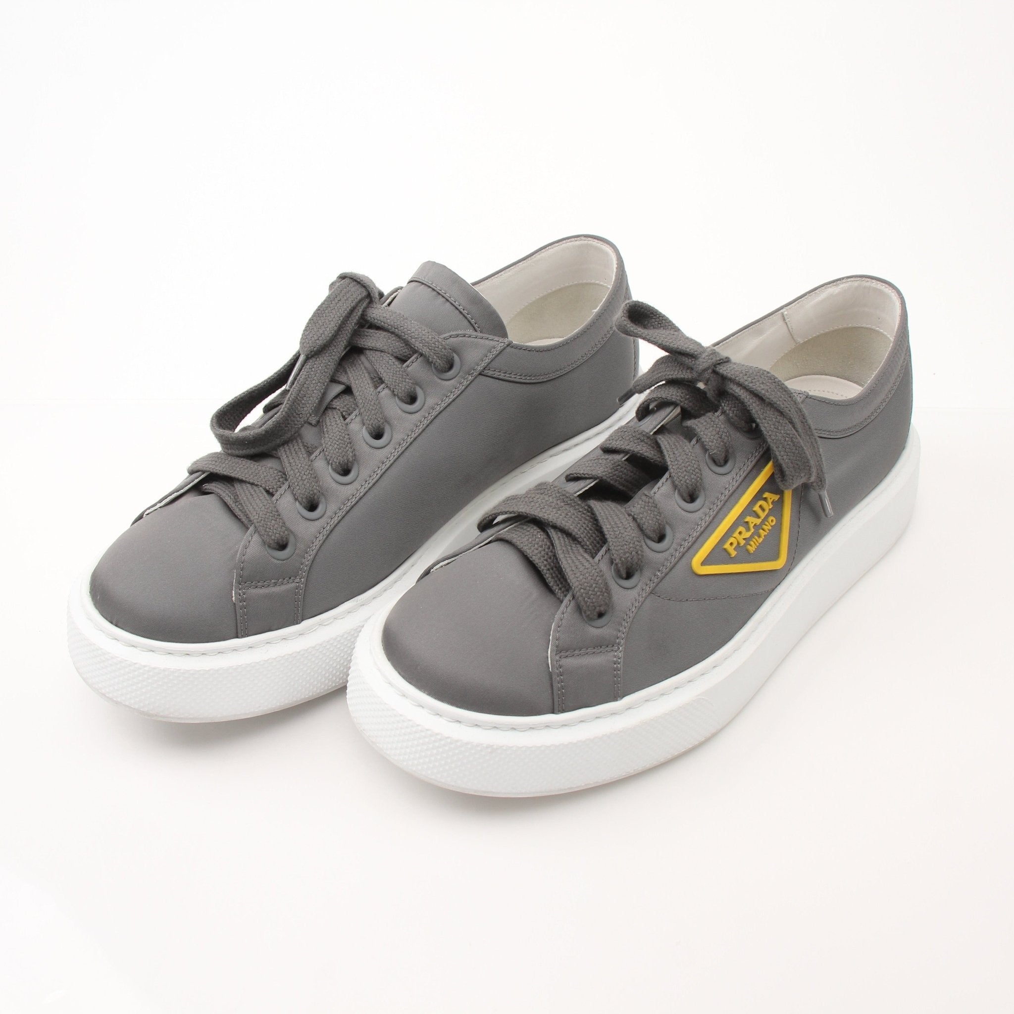 Prada gray Re-Nylon gabardine platform sneakers with white soles and lace-up design, displayed on a plain background.