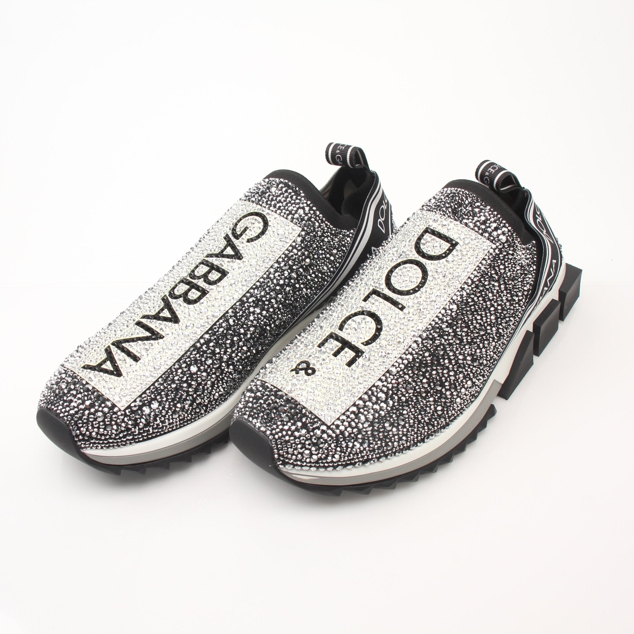 Gold & Beyond Dolce & Gabbana Sorrento Crystal Logo slip-on sneakers with white fabric, crystal logo details, and rubber soles.