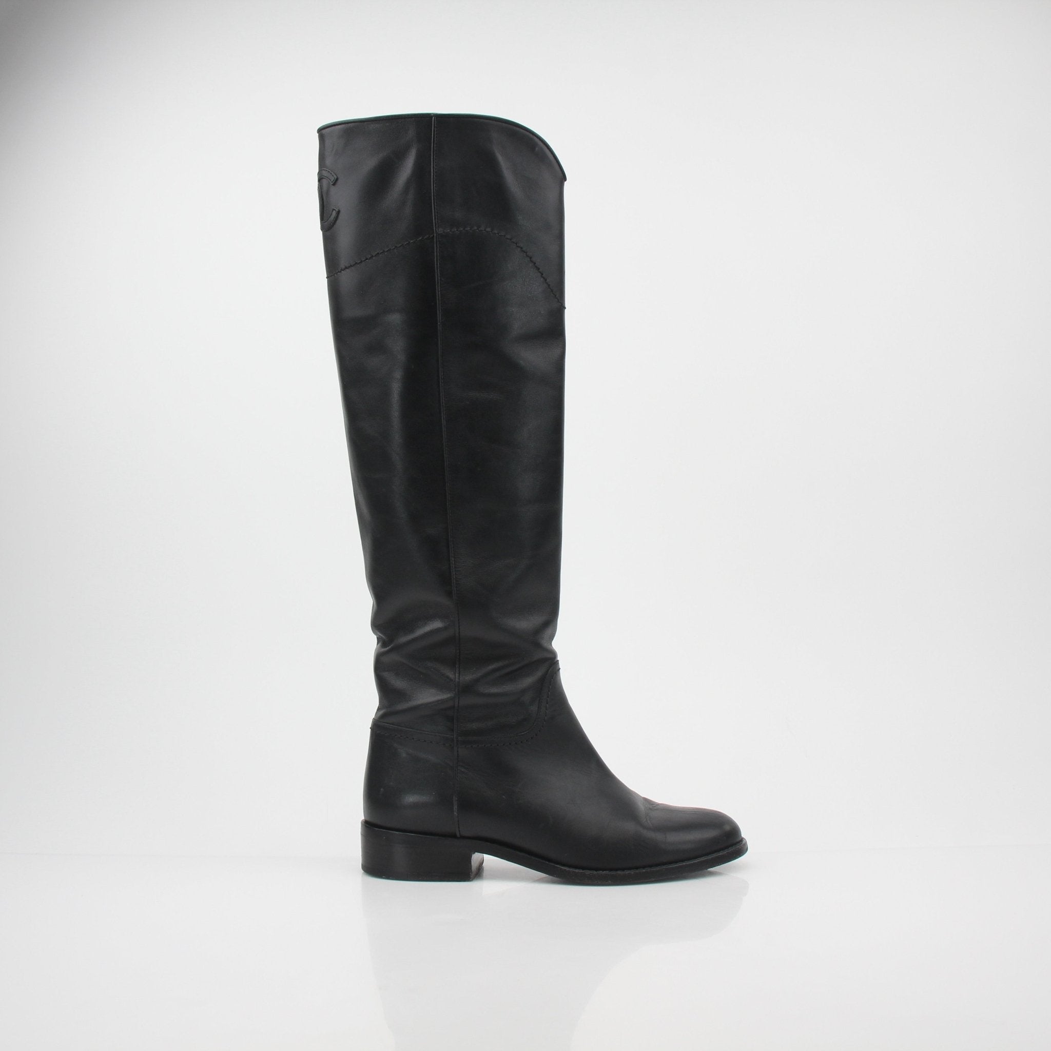 Black leather Chanel CC knee-high riding boots with gold accents, stylish and elegant shoes from Gold & Beyond.