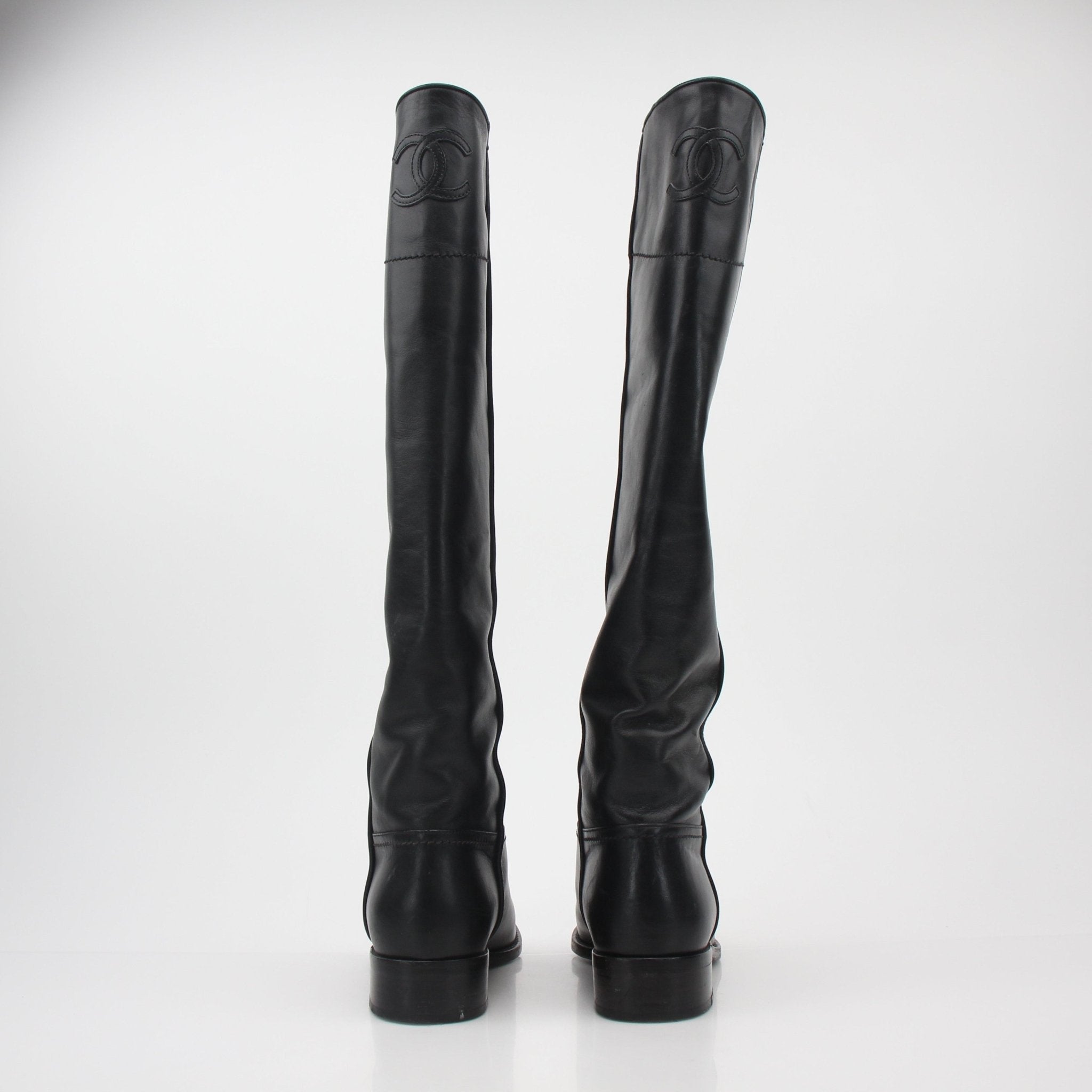 Gold & Beyond Chanel black leather CC knee-high riding boots, stylish shoes with classic design and buckle details.