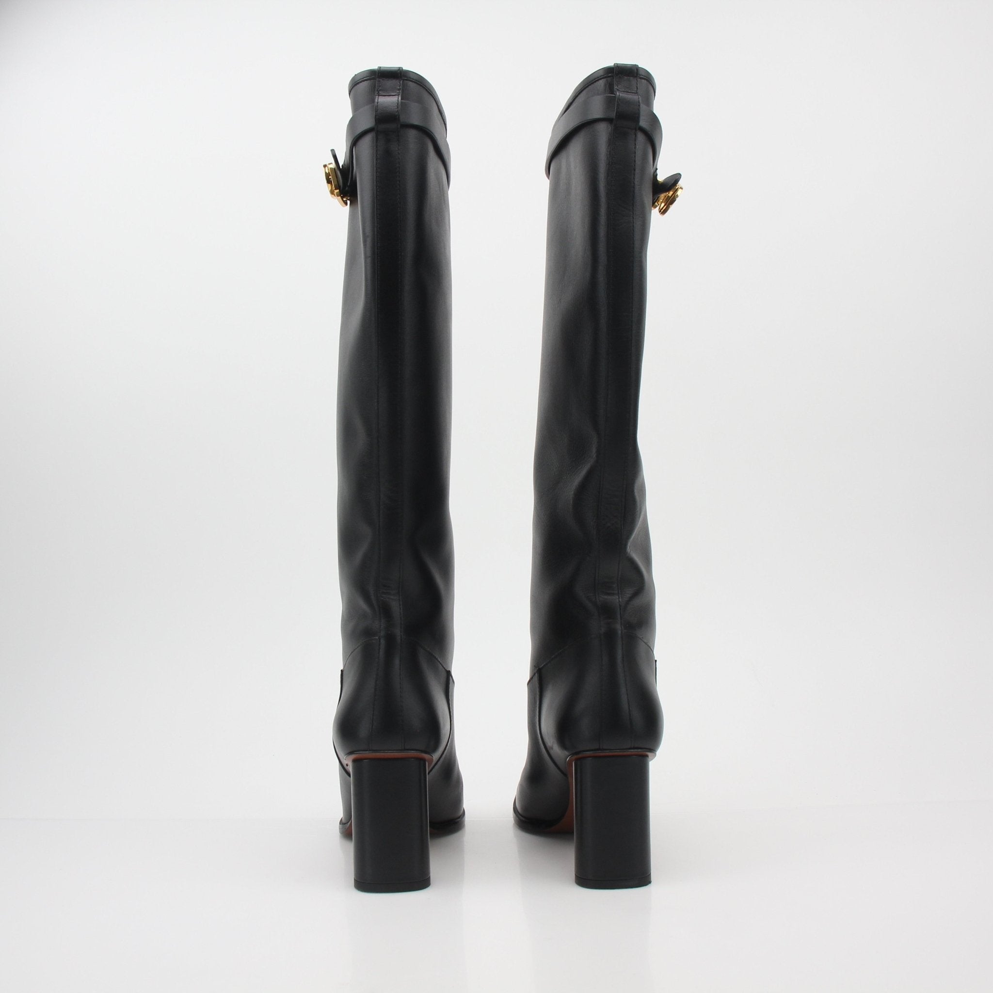 Black leather Christian Dior Empreinte heeled boots with sleek design and pointed toes, displayed on a neutral background.