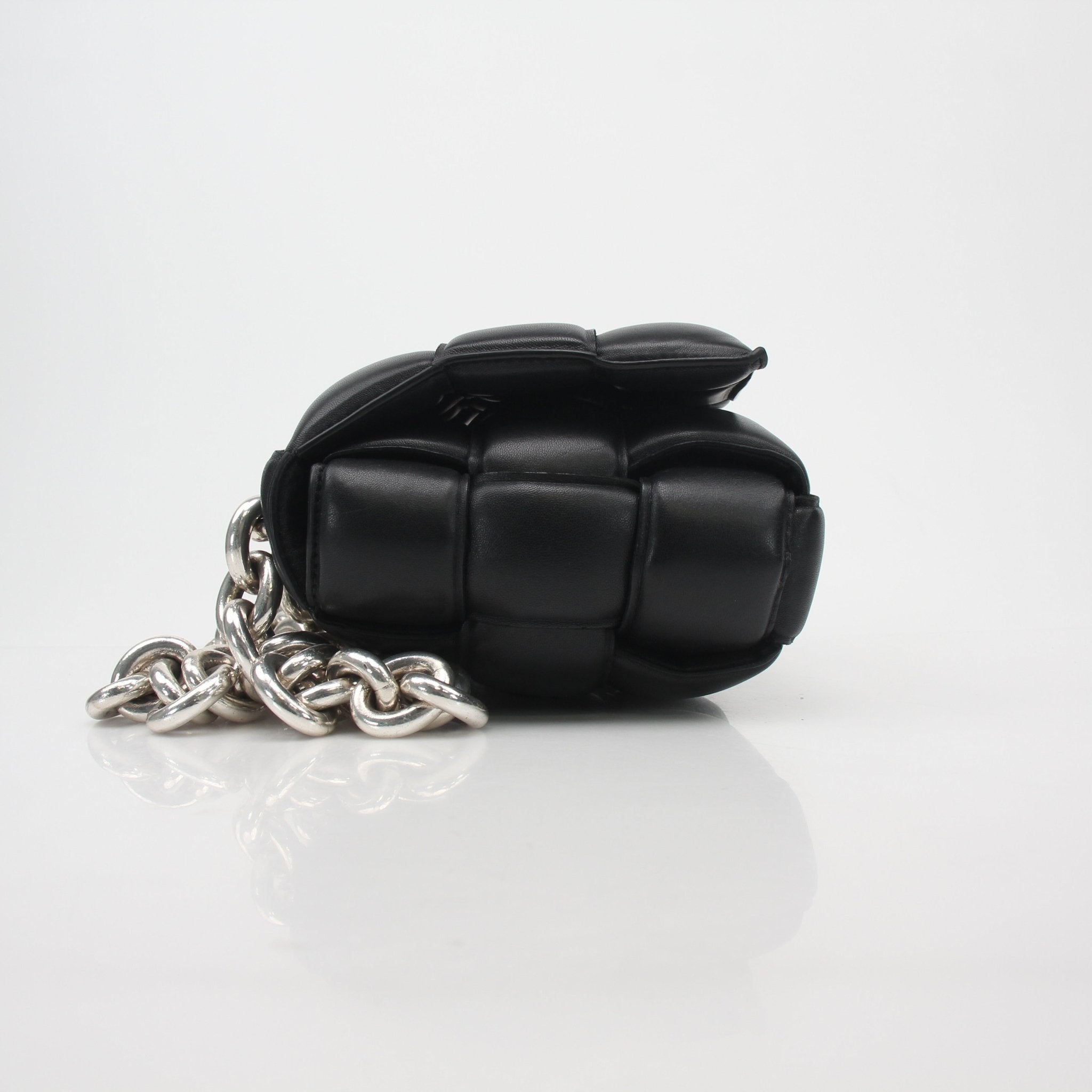 Black Bottega Veneta padded cassette chain shoulder handbag with gold accents, stylish and luxurious accessory.