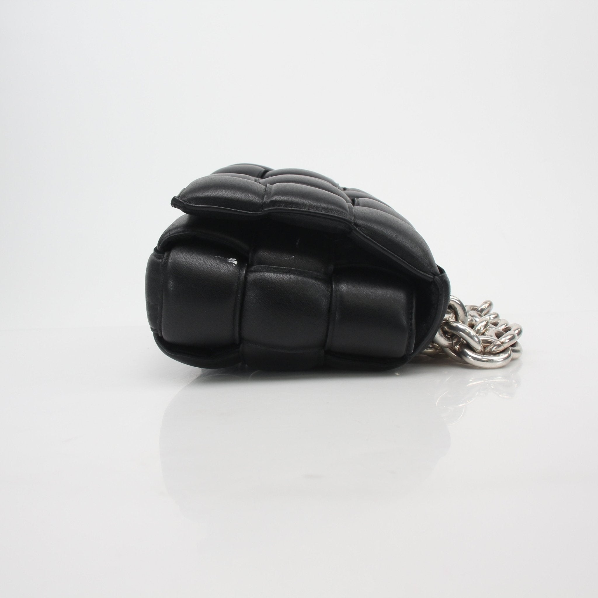 Black padded cassette chain shoulder handbag by Bottega Veneta with gold hardware, featuring a structured design and adjustable strap.