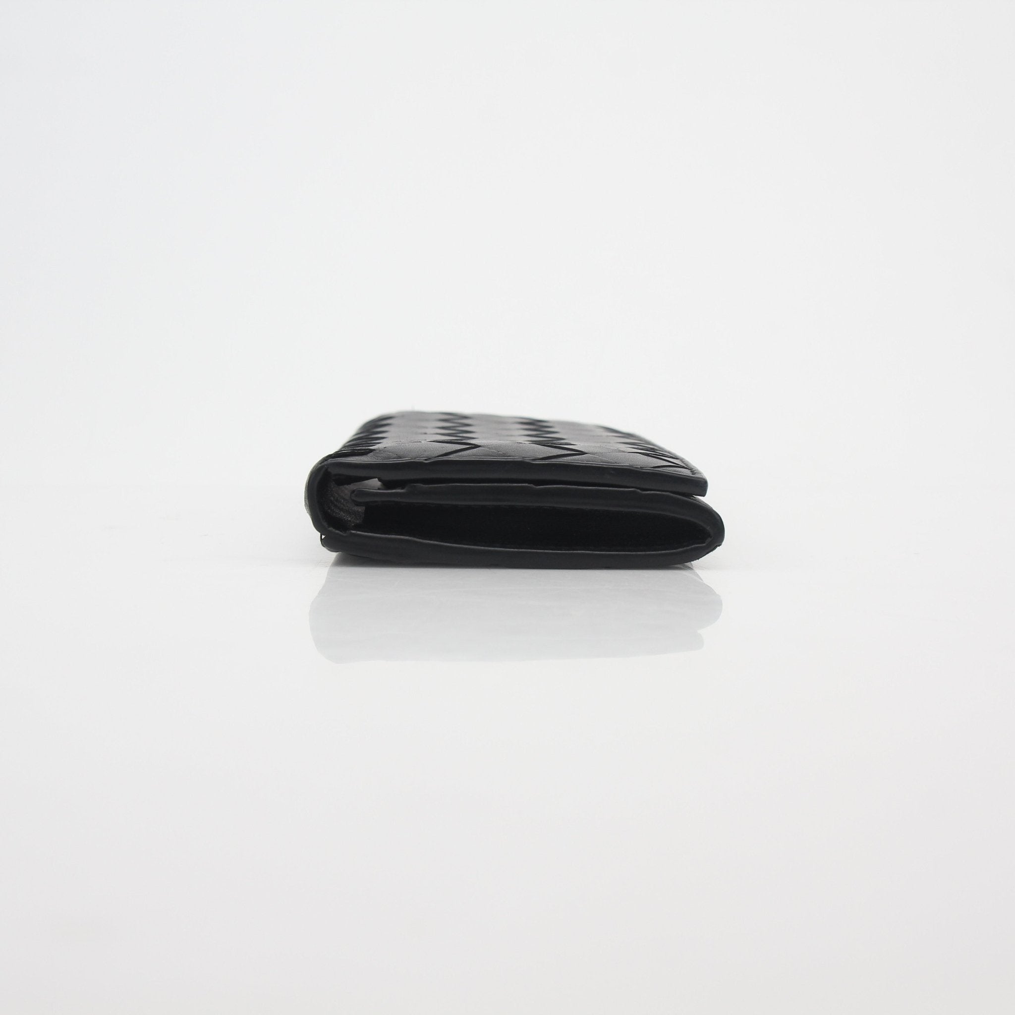 Black Bottega Veneta Intrecciato leather continental wallet with gold accents, showcasing the textured woven design and sleek exterior.