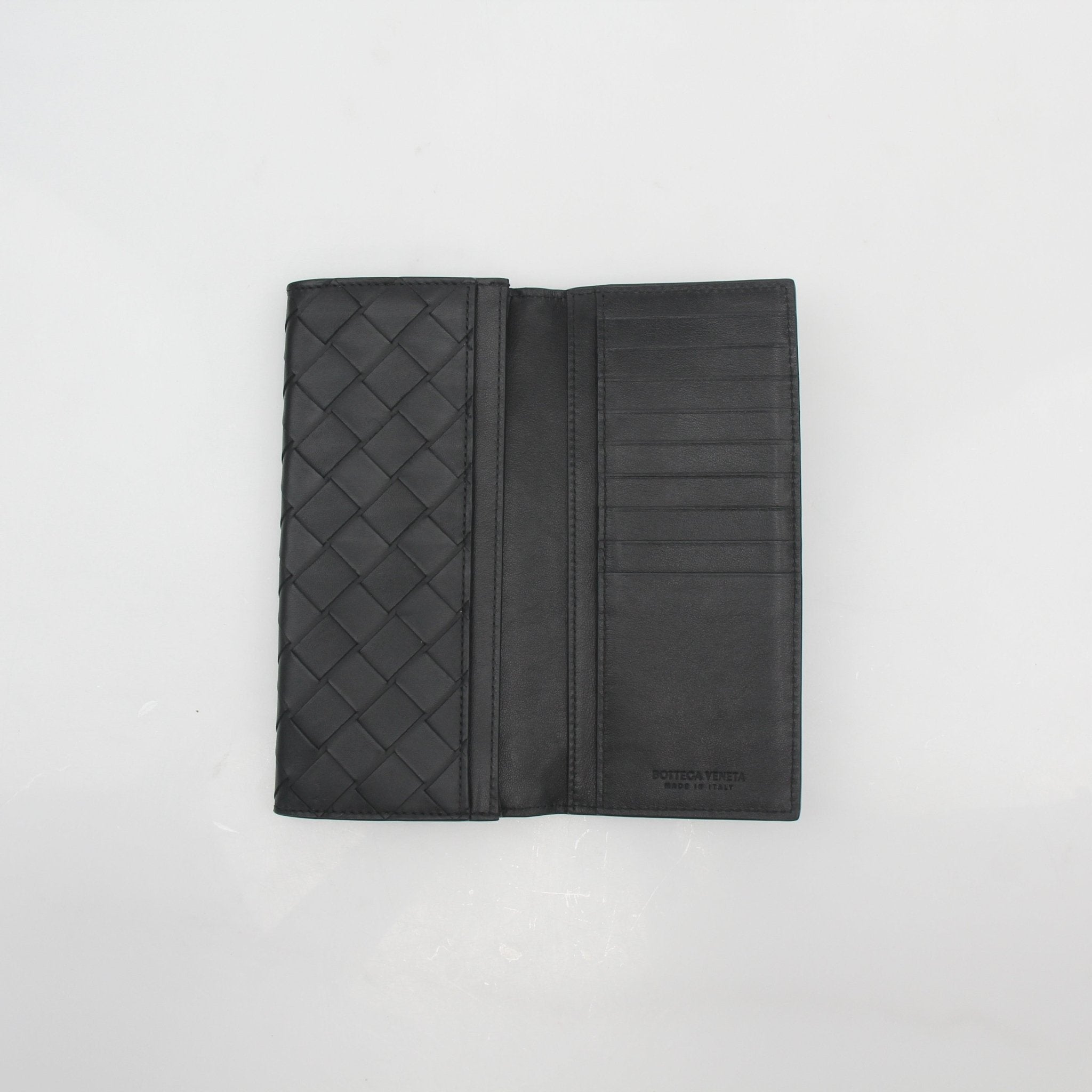 Black Bottega Veneta Intrecciato Continental Wallet with woven leather design, displayed open showing multiple card slots.