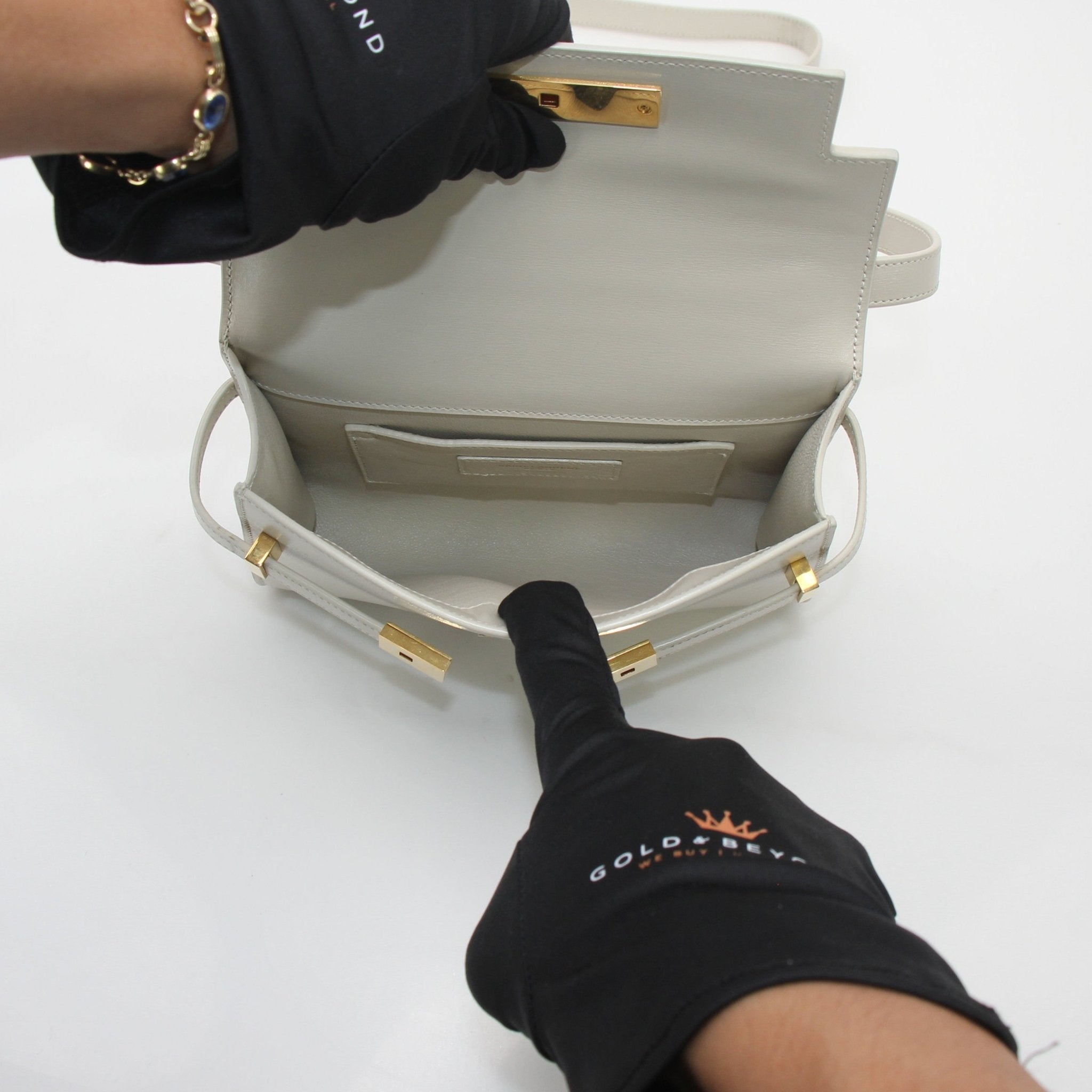 White Saint Laurent Manhattan shoulder bag with gold hardware, featuring a sleek design and adjustable strap.