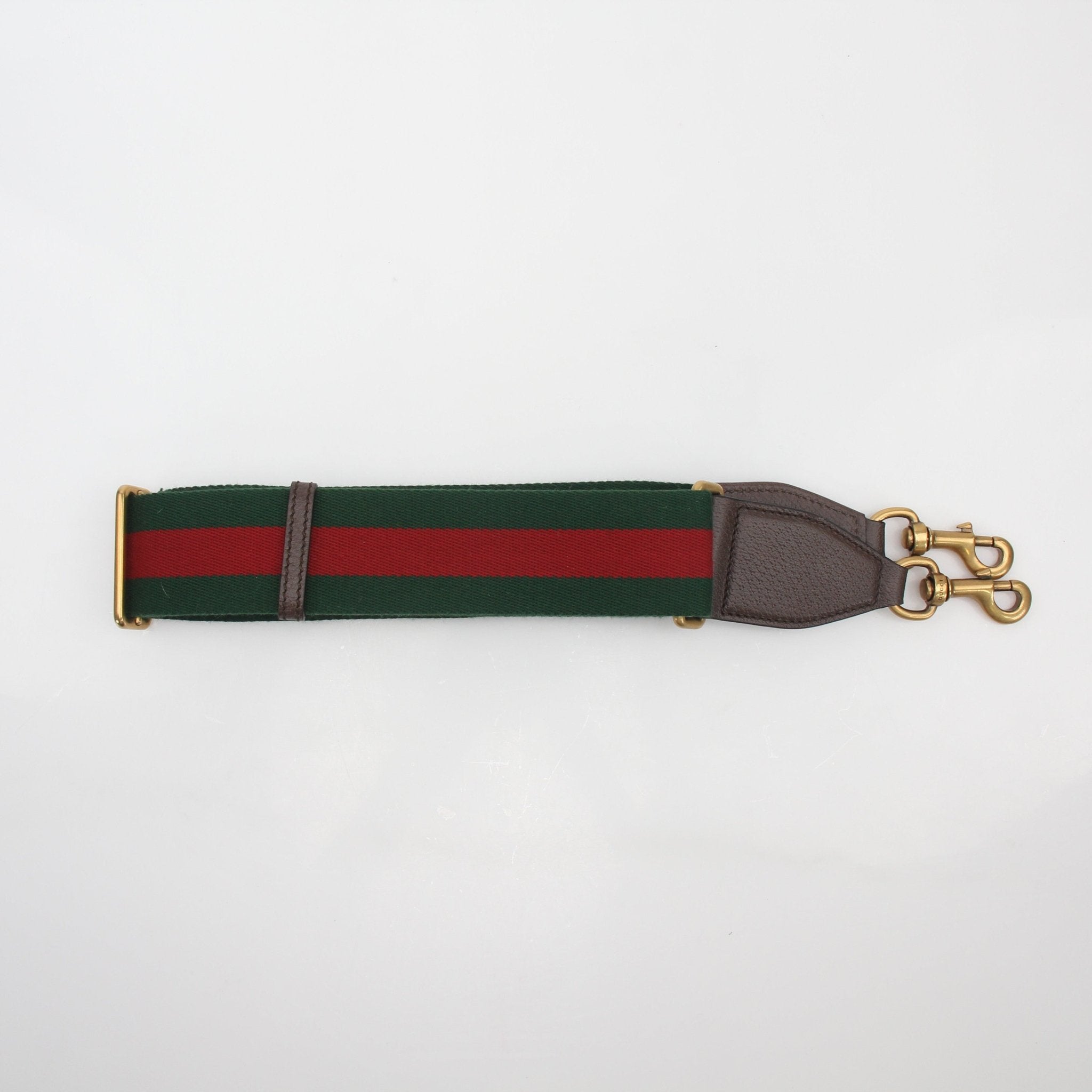 Gucci x Adidas GG Supreme duffel travel bag with gold accents and adjustable shoulder strap, showcasing luxury and sporty style.