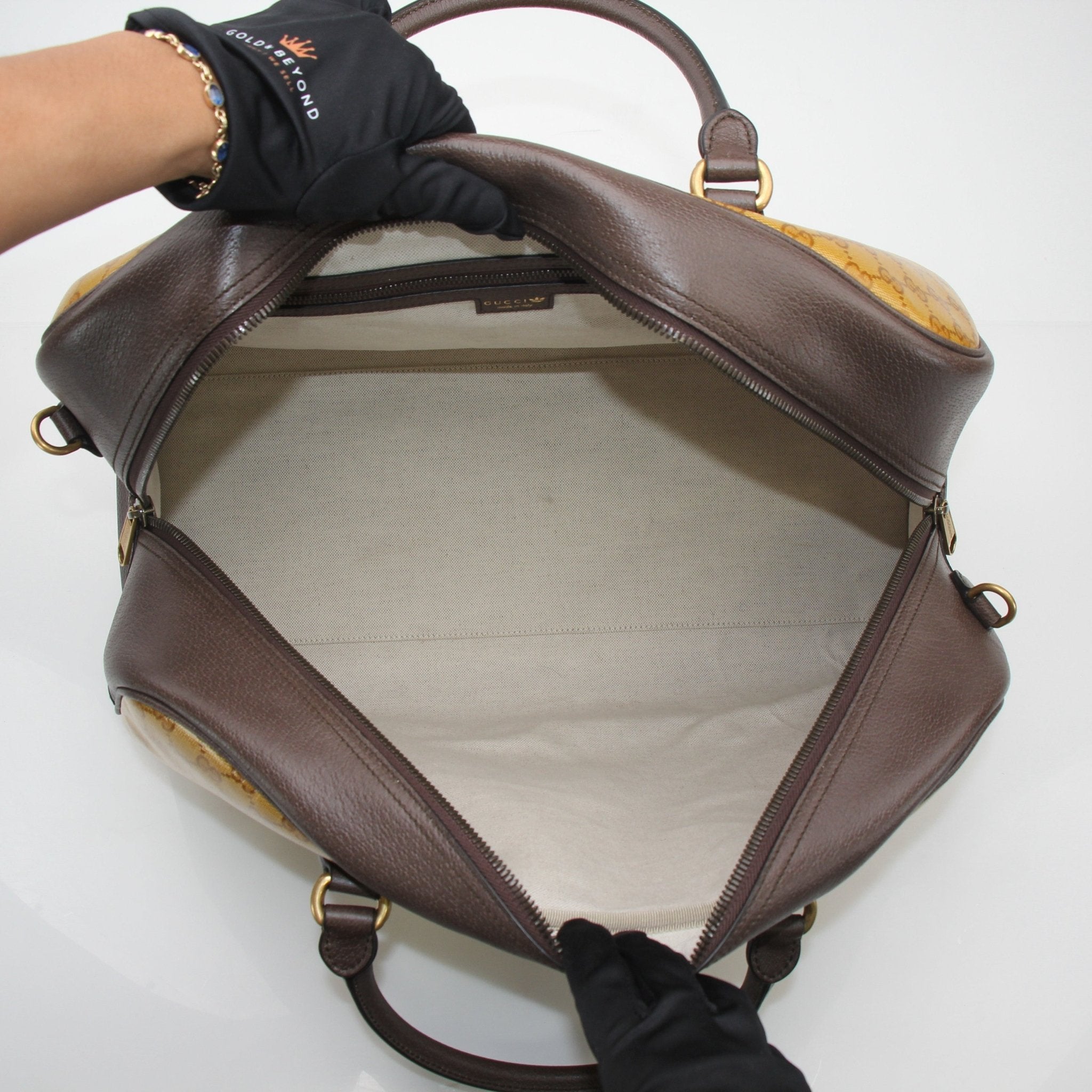 Gucci x Adidas GG Supreme duffel travel bag with monogram pattern and sturdy handles, designed for stylish travel.