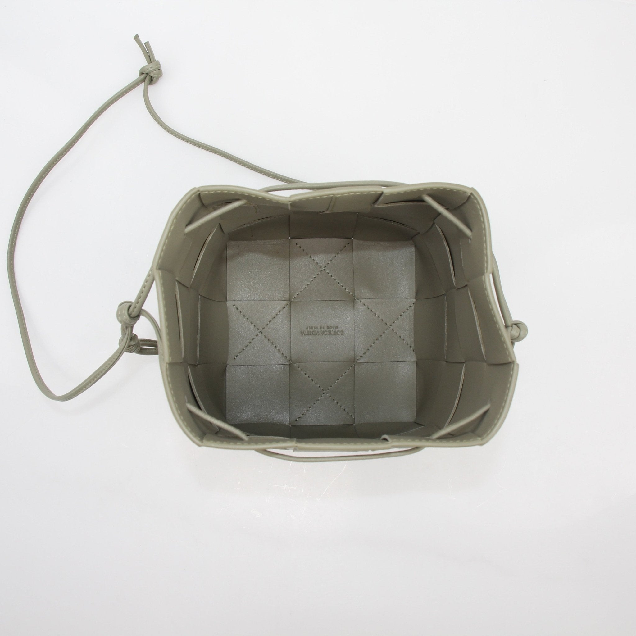 Gold & Beyond Bottega Veneta Chalk Cassette Bucket Bag handbag with woven leather texture and compact, stylish design.