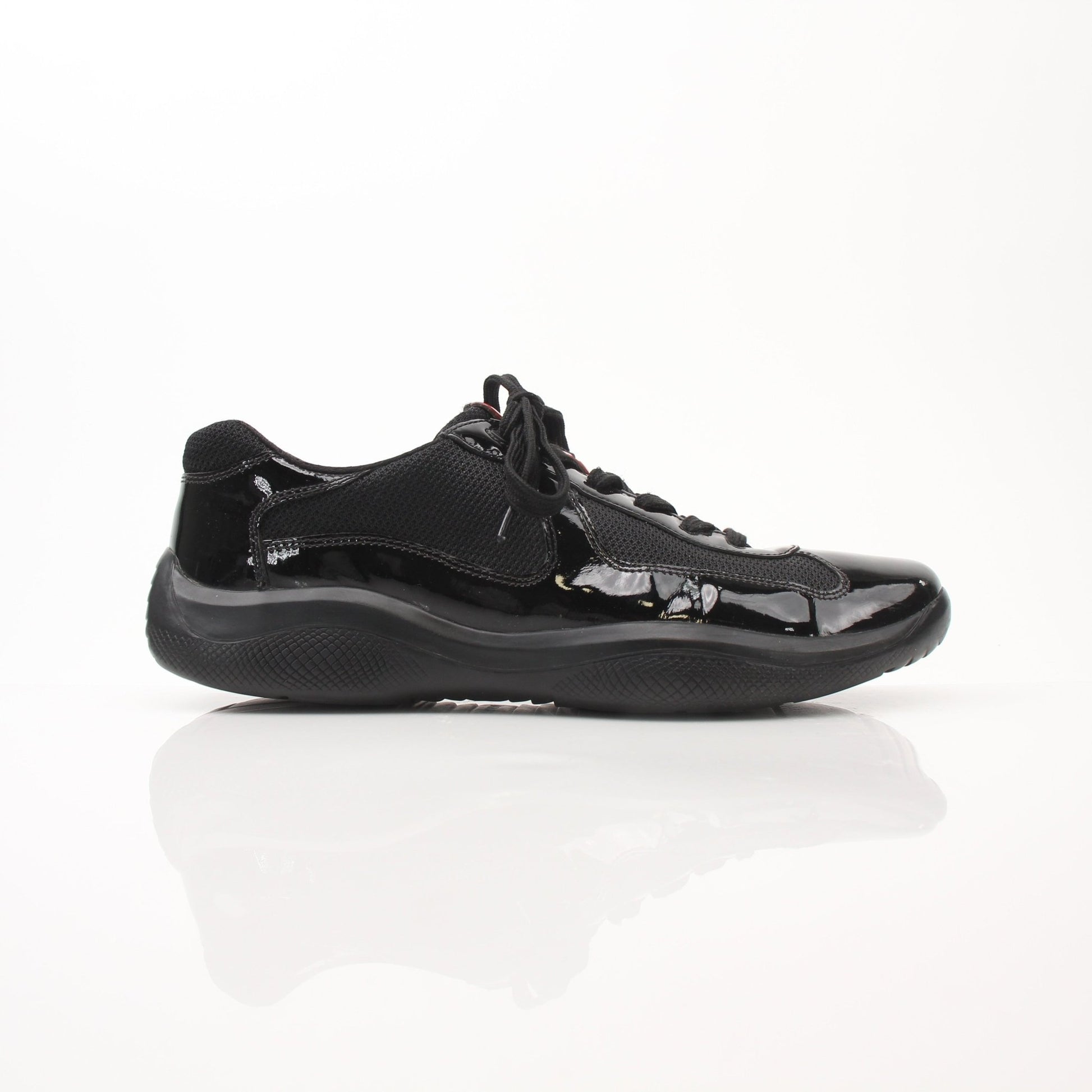 Black patent leather Prada men's America’s Cup sneakers with sleek design and white rubber soles.