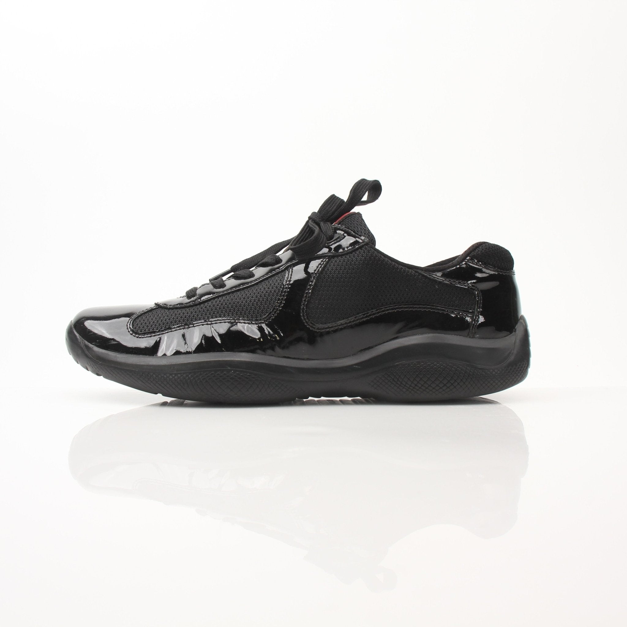 Prada men's black patent leather sneakers with sleek design, featuring lace-up closure and modern styling.