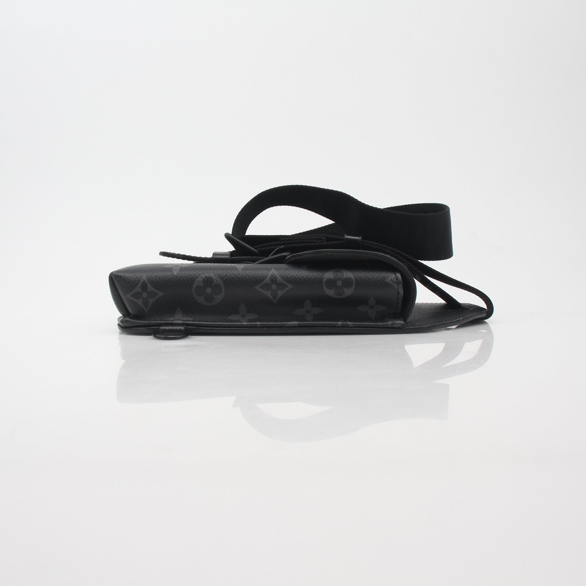 Louis Vuitton Monogram Eclipse sling bag, black and gray handbag with adjustable strap and monogram pattern, stylish and compact.