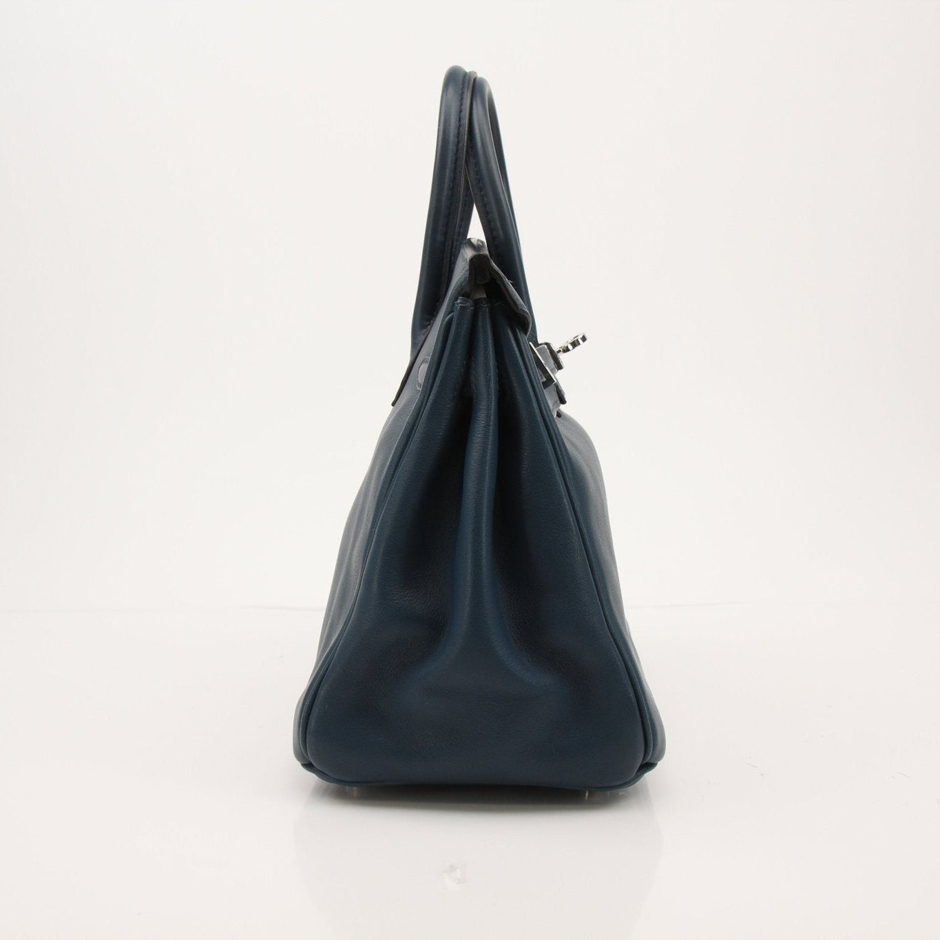 Hermès Birkin 25 blue leather handbag with gold hardware, elegant and structured design, displayed on a neutral background.