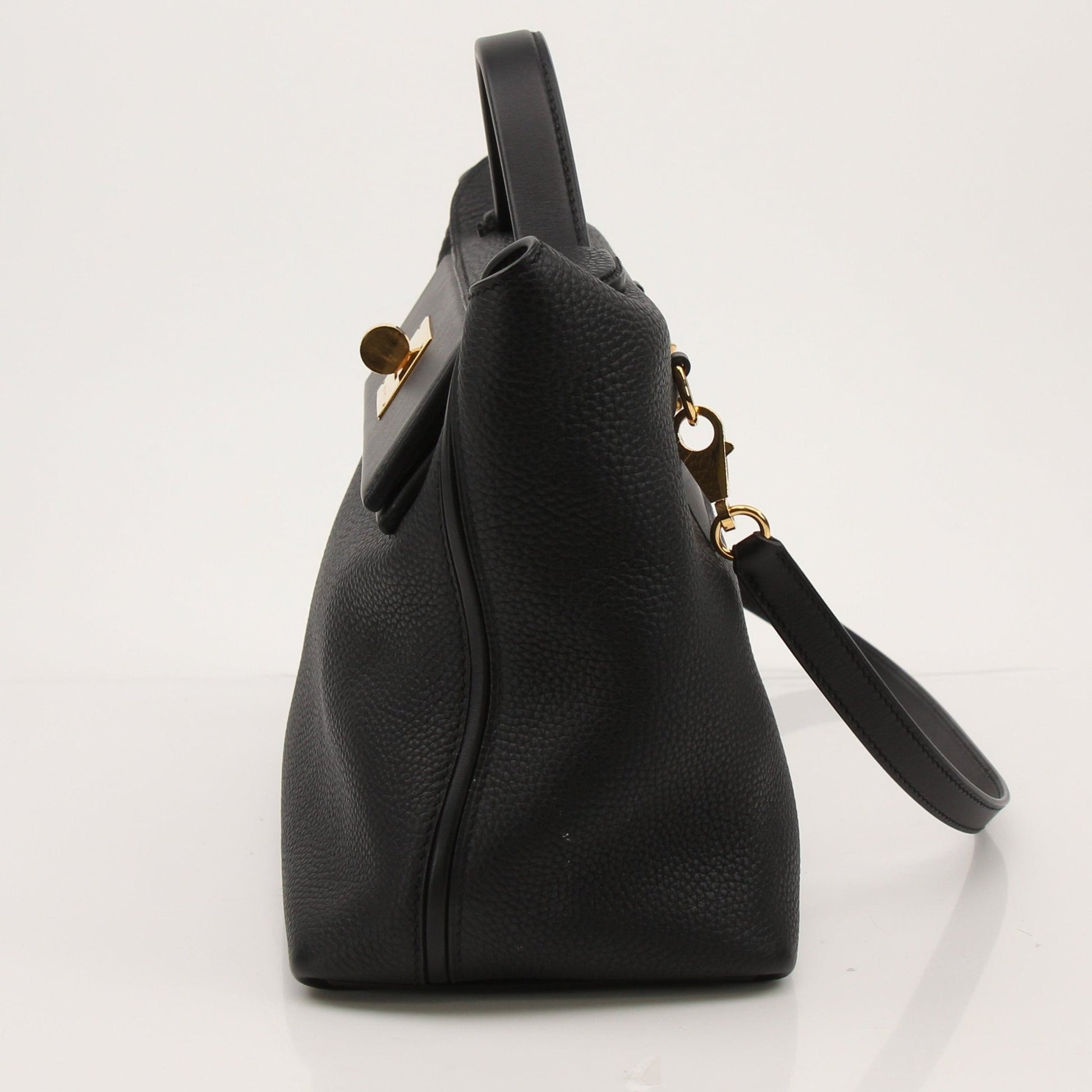 Hermès Top Handle Clemence handbag in beige leather with gold hardware, featuring structured design and sturdy top handles.