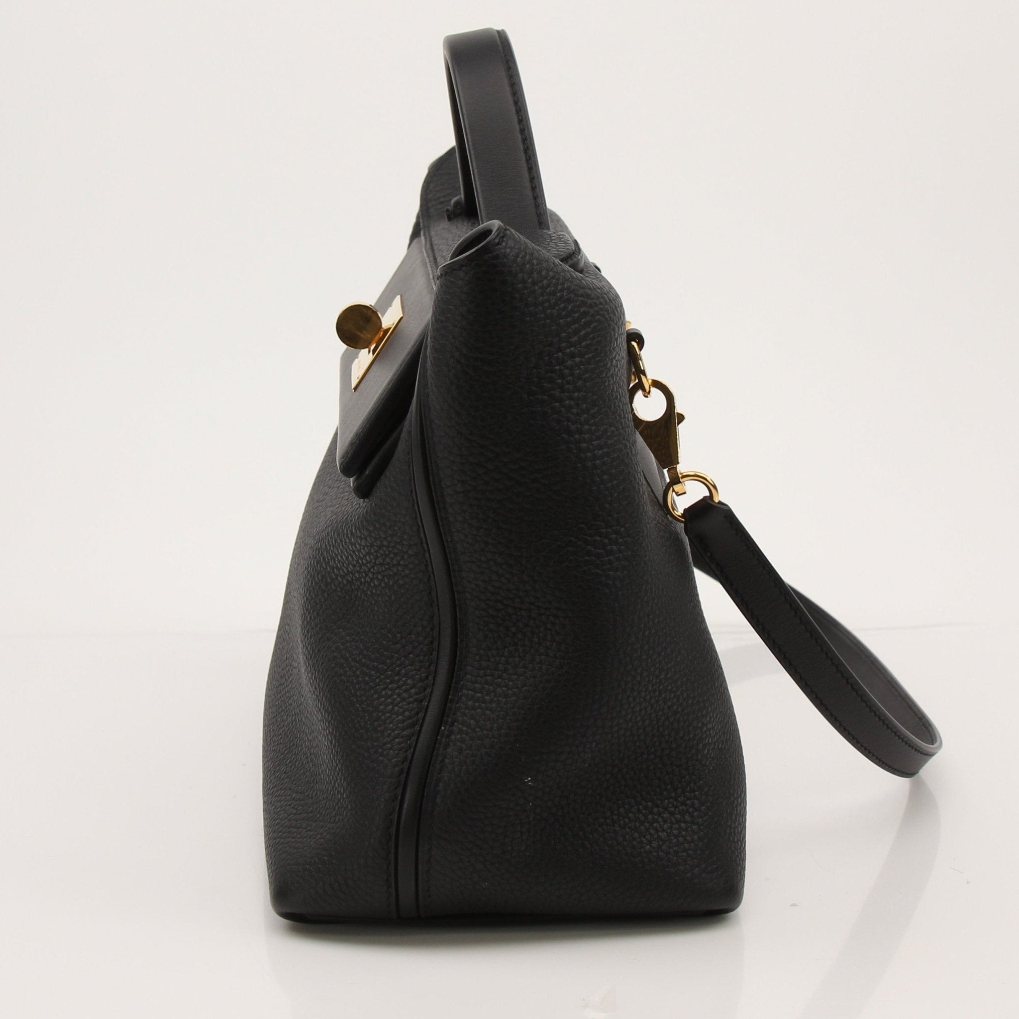 Hermès Top Handle Clemence handbag in beige leather with gold hardware, featuring structured design and sturdy top handles.